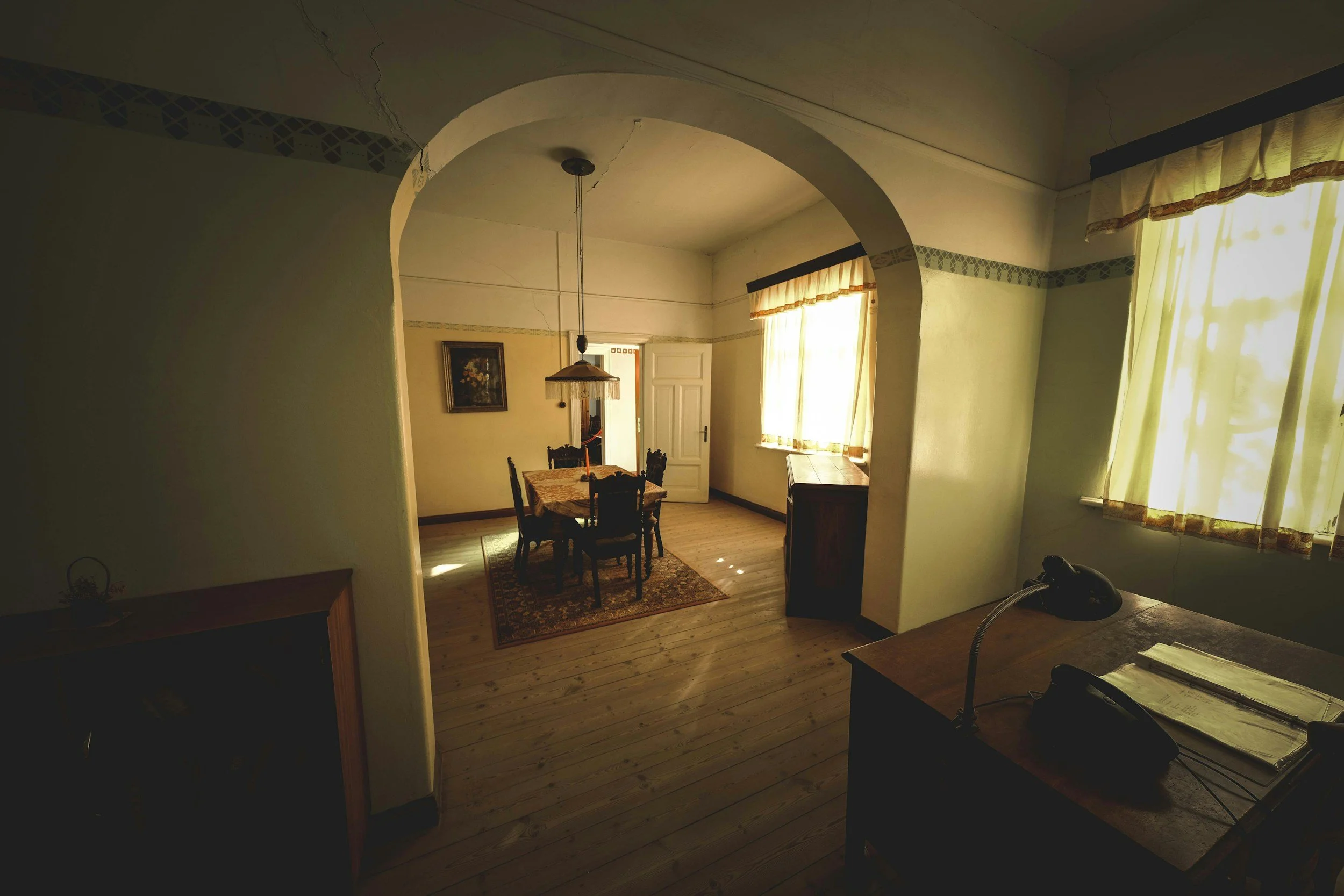 room with desk and chair looking out onto dining room