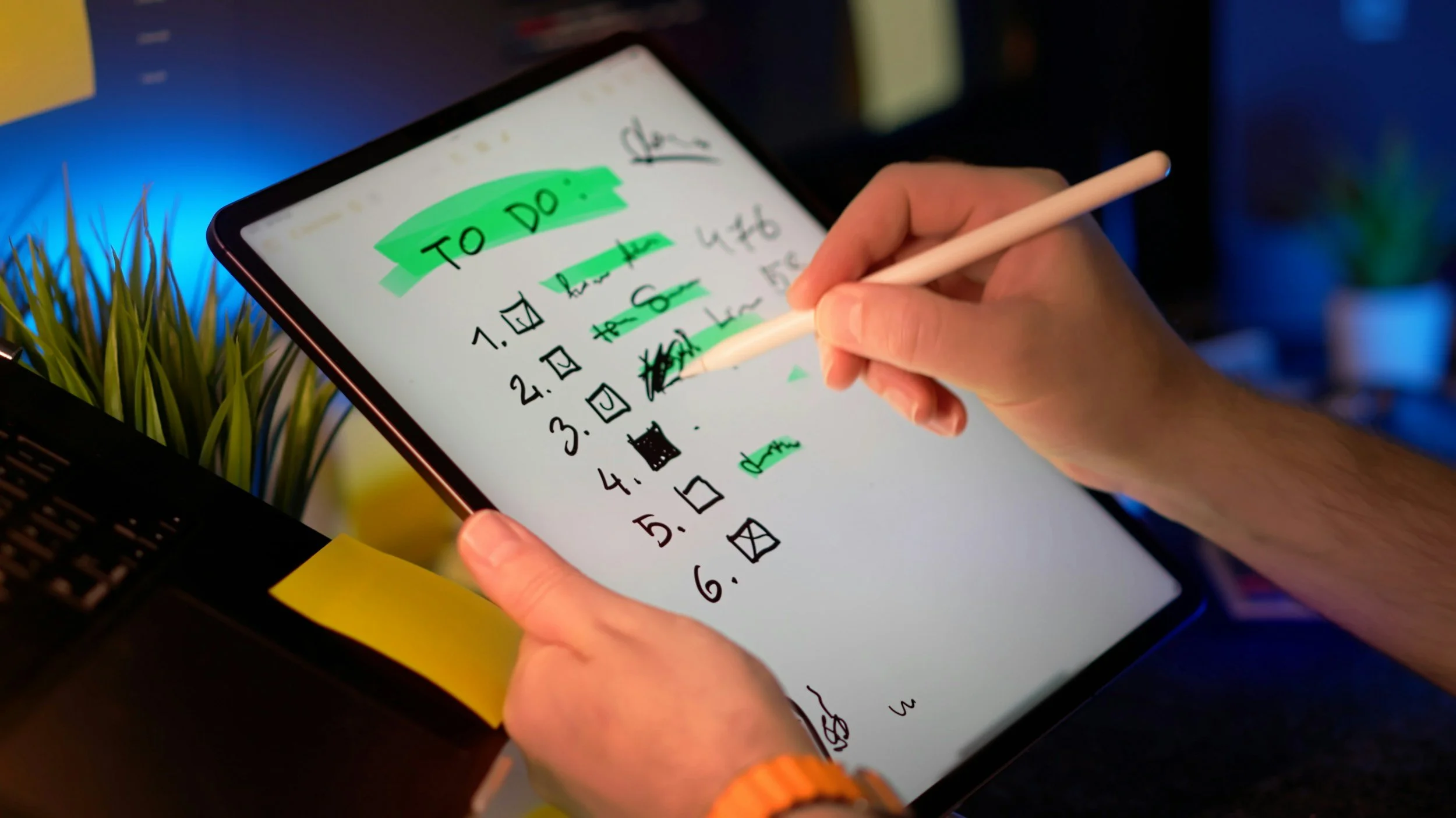 person using stylus on digital notepad