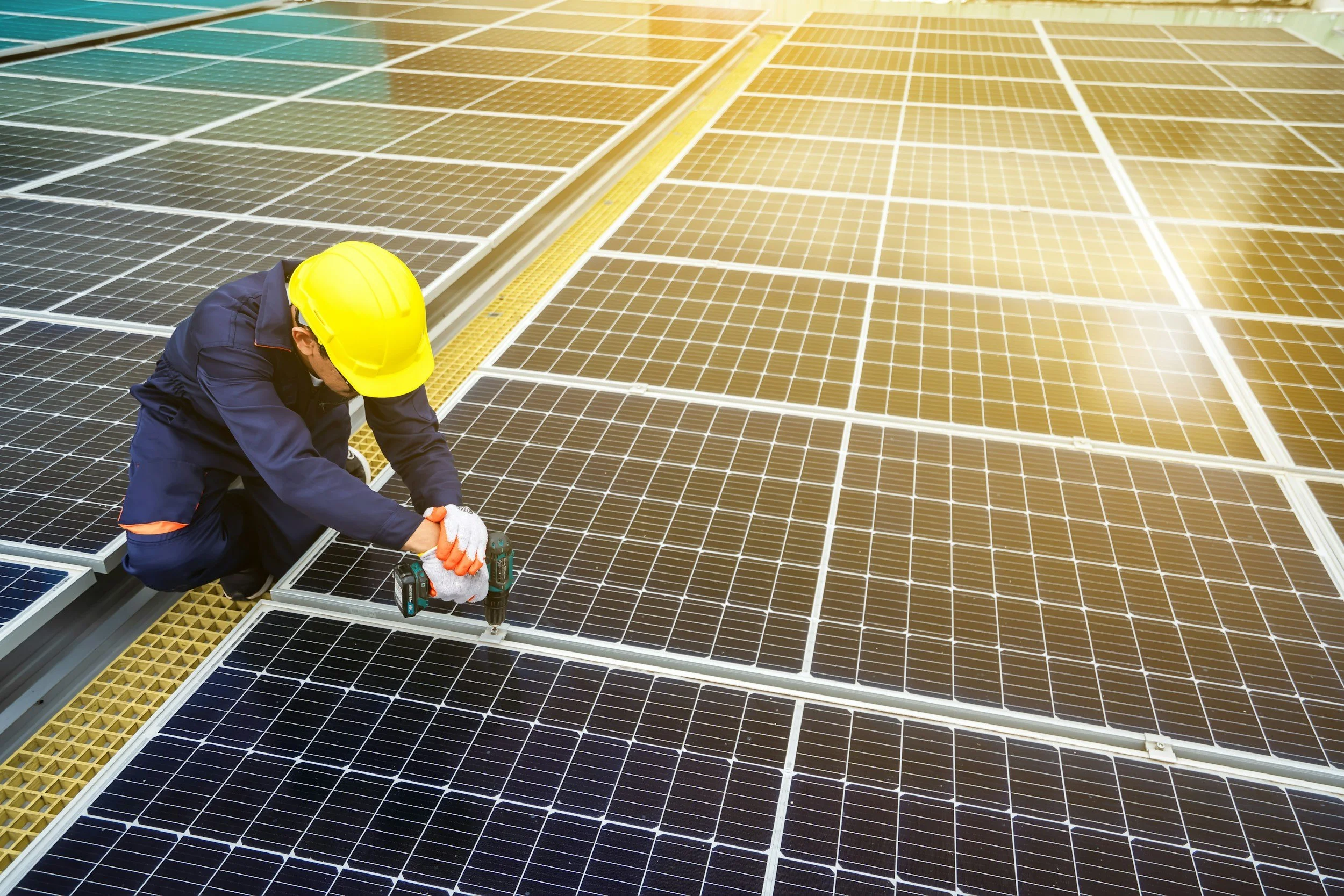 man in a hardhat working on a solar panel