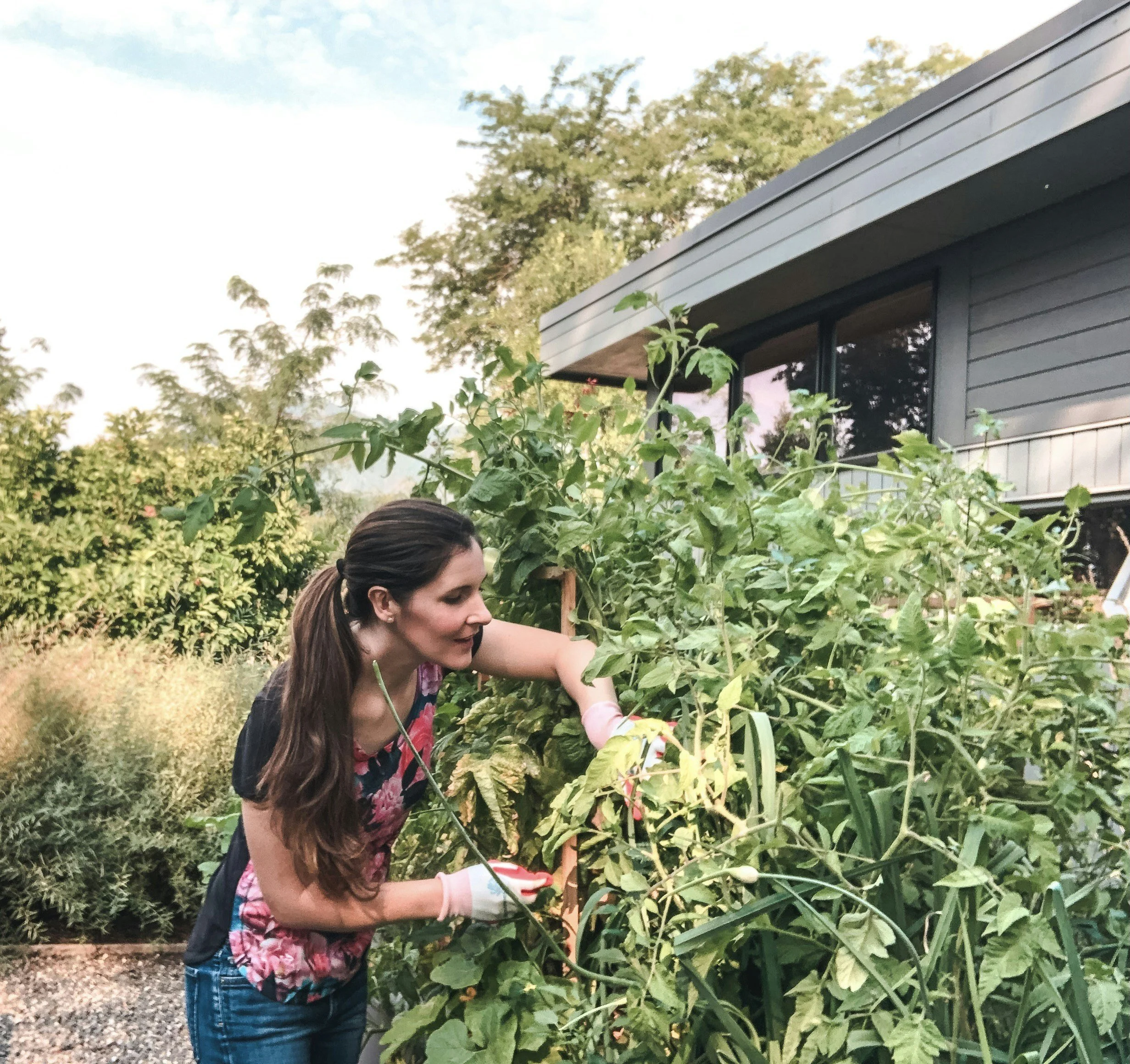woman in a floral shirt tending to a garden