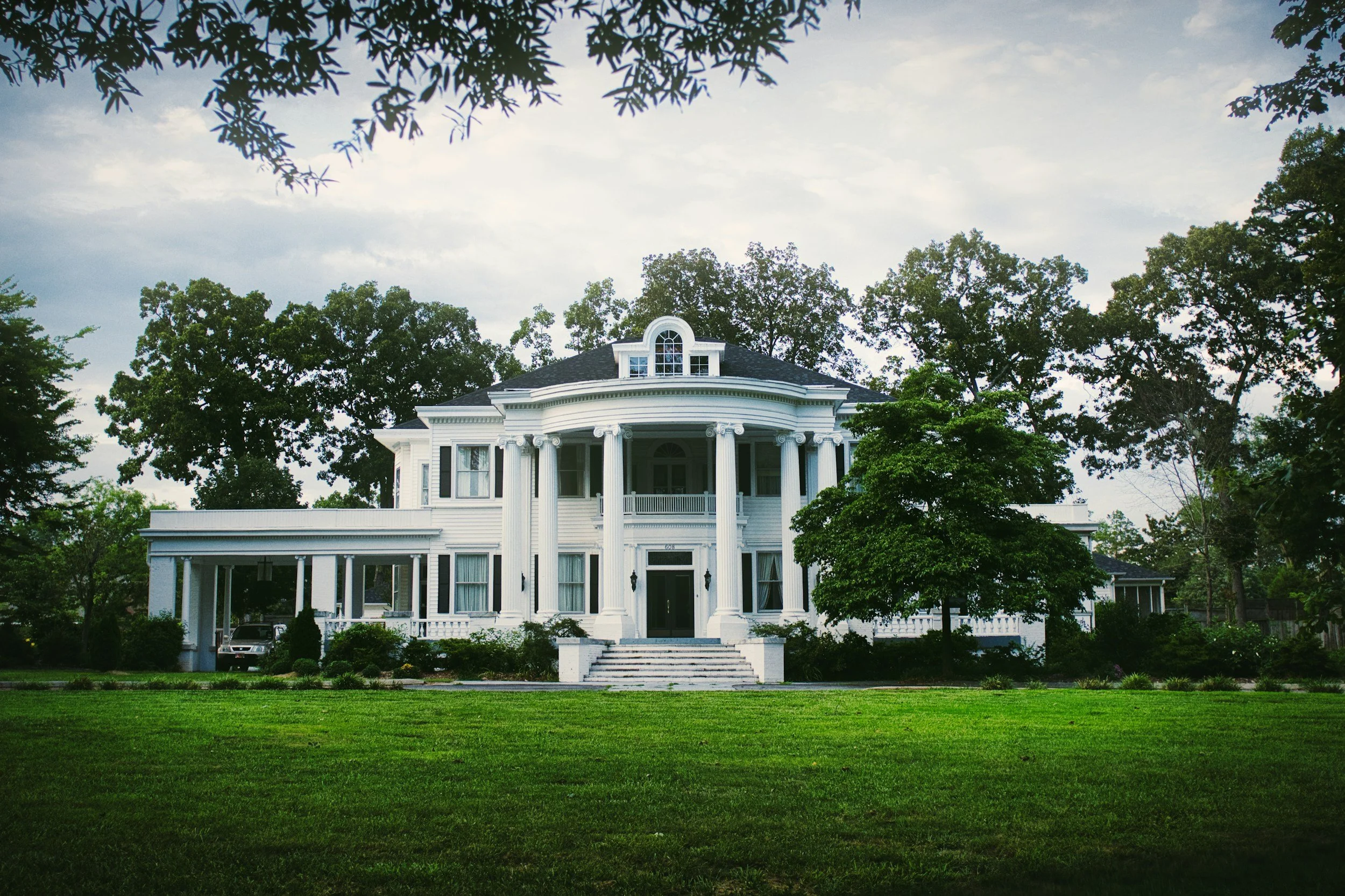 lush green lawn in front of a large white house