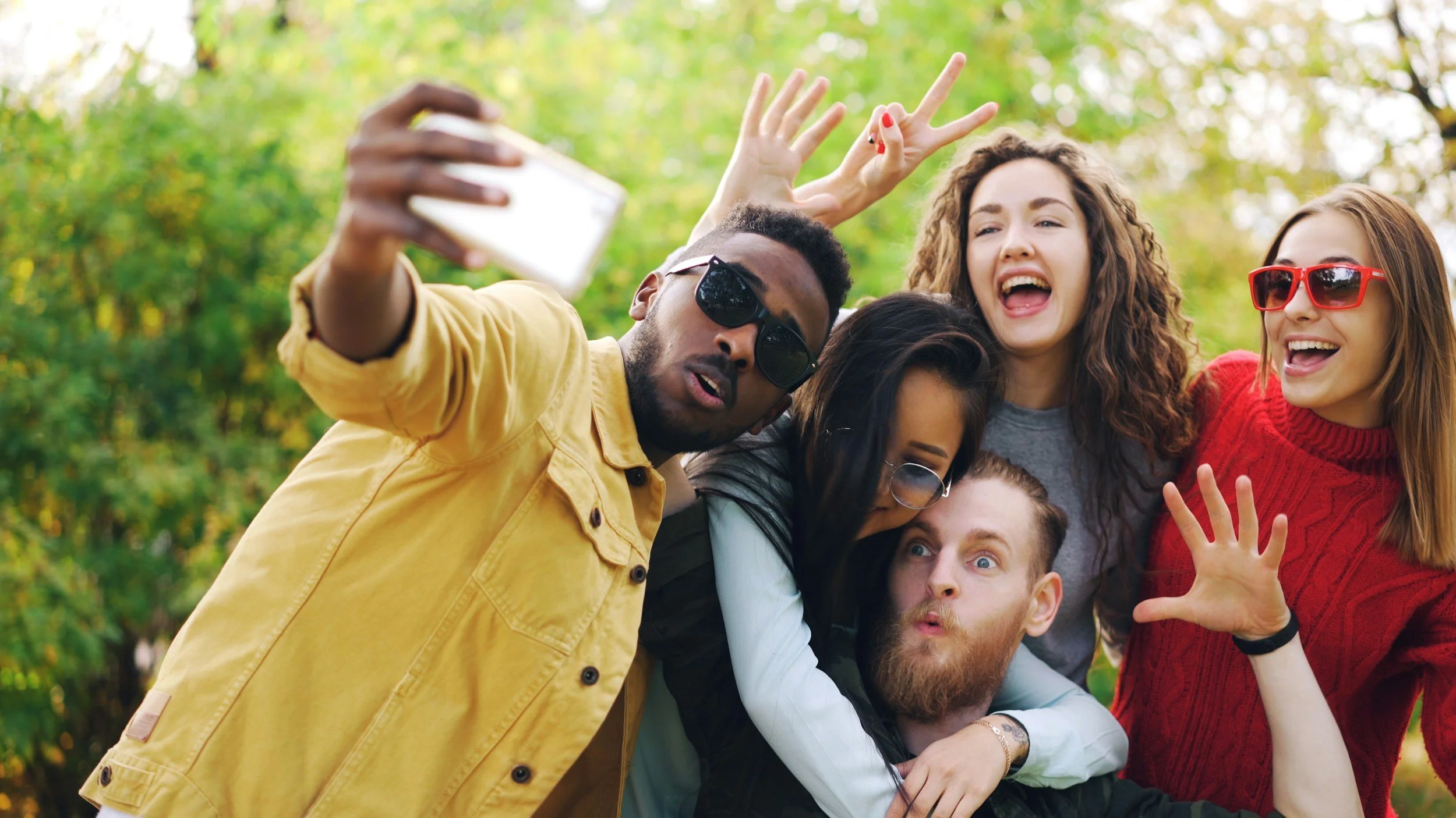diverse group of friends taking a selfie outdoors