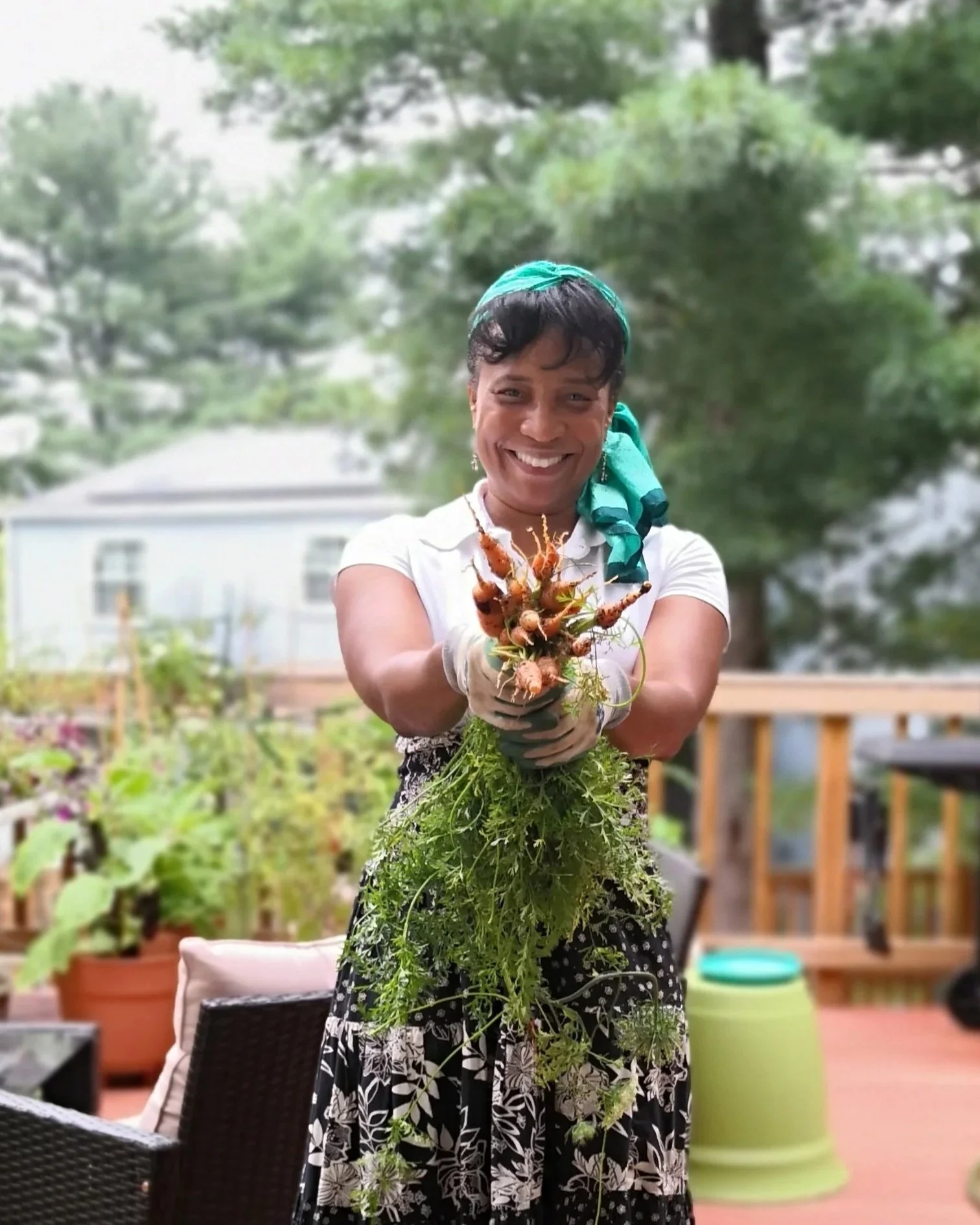 woman holding a bunch of freshly harvested carrots