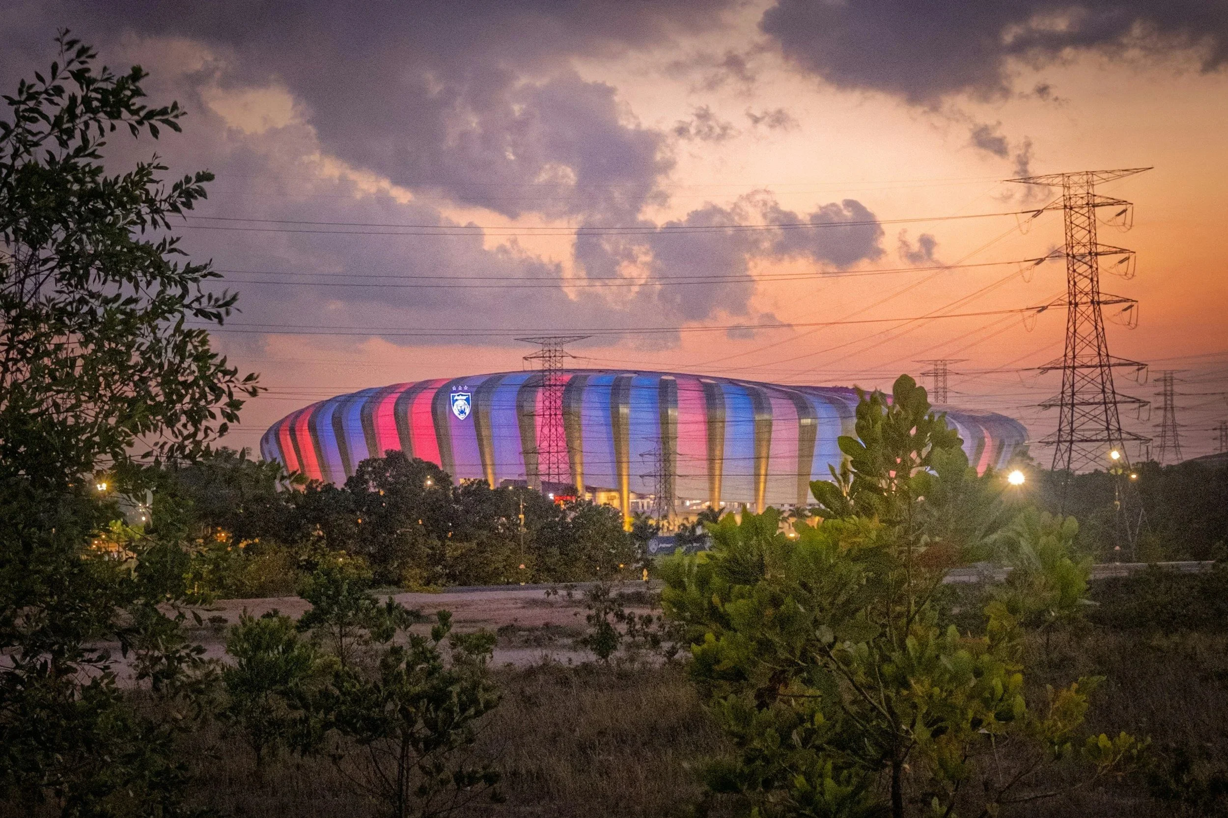 stadium in red and blue lights under a sunset sky
