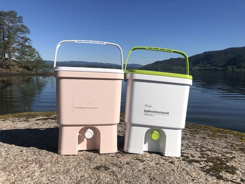 2 bokashi bins outside near a body of water