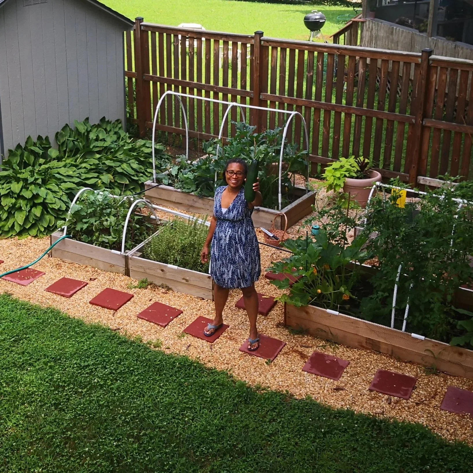 author holding large zucchini harvested from her garden