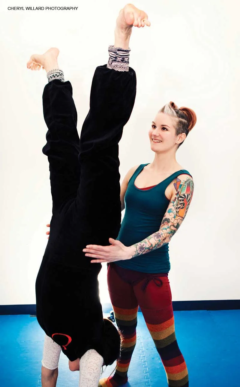 Katie spotting a student in Hand Balance class