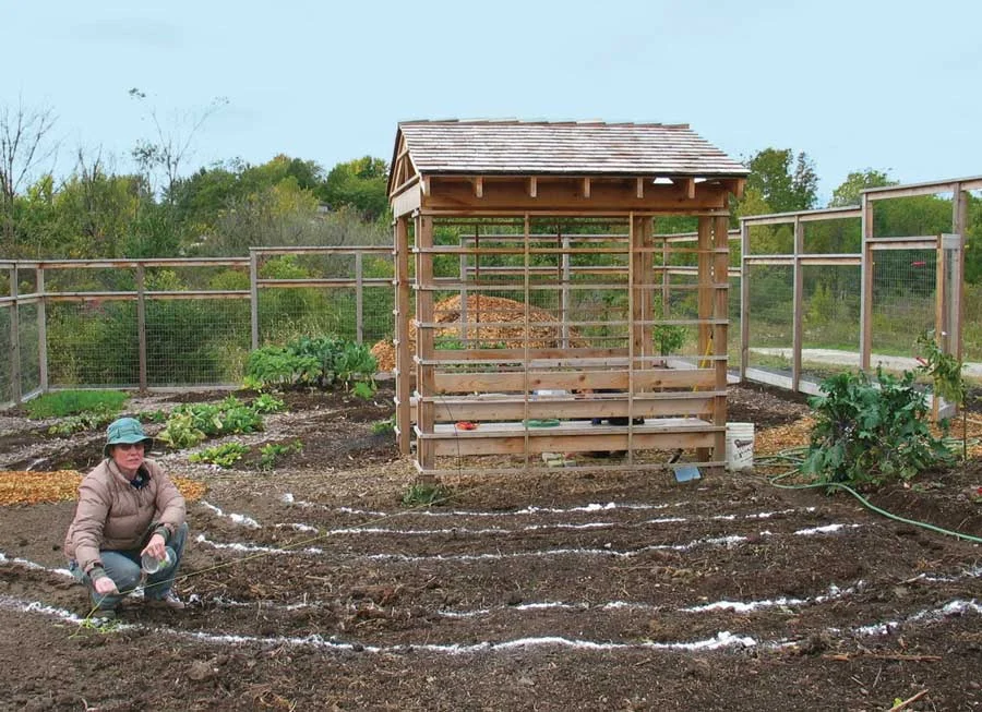 Erica Kempter laying out vegetable garden beds for a Nature and Nurture landscaping client
