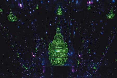 Photo from the Fa-Tsang Mirror House at Tsogyelgar. The alchemical chamber draws the MindHeart into natural contemplation. An octagonal room, mirrored on all sides, with a single Buddha statue and LED lights creates infinite Buddhas and infinite lights expanding though infinite space — all within a small room.