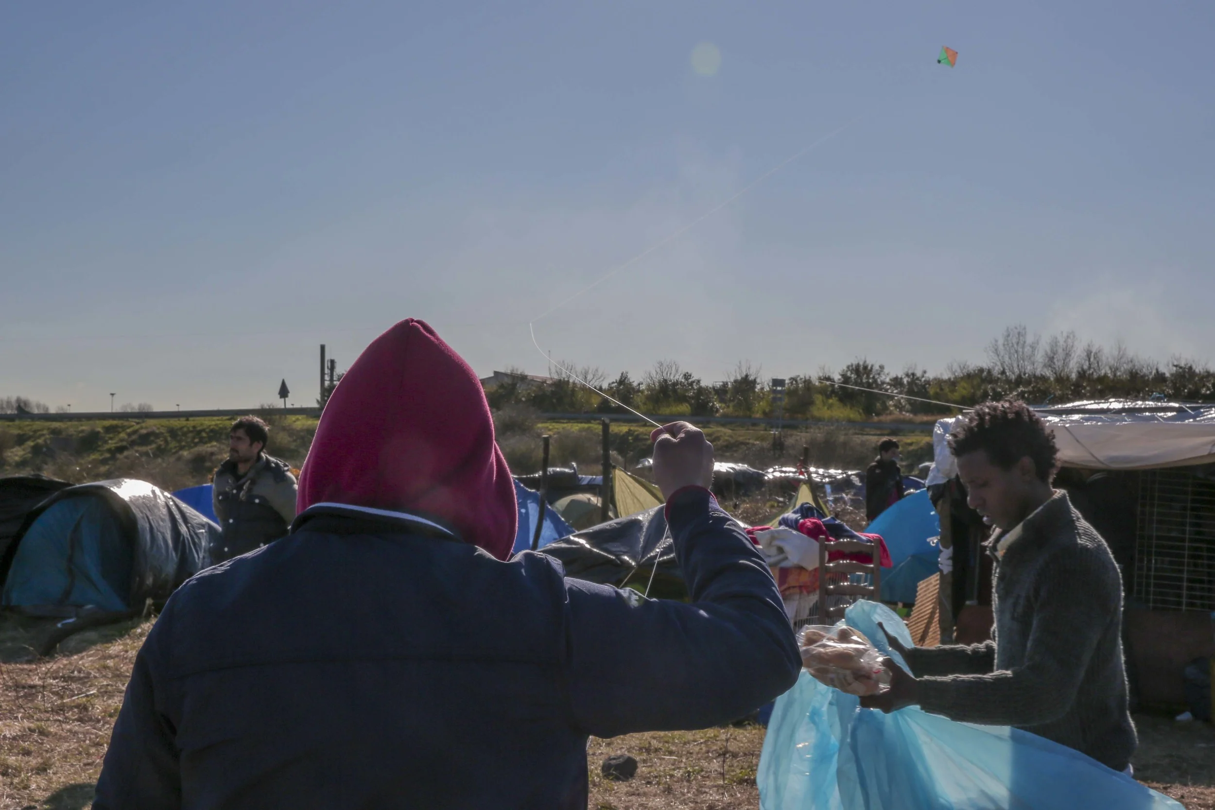 An Afghan man flies a kite in the new "jungle" in Calais