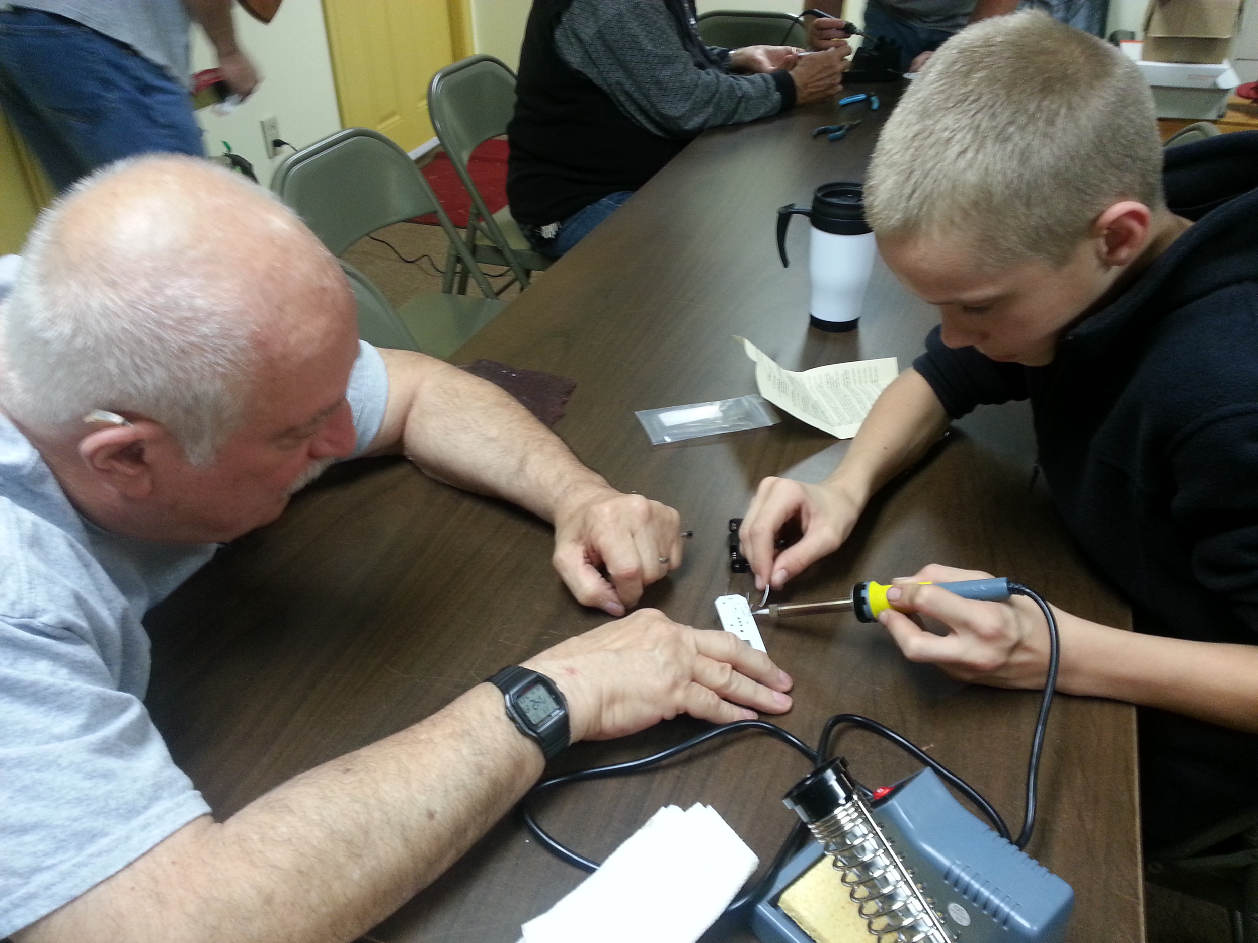After completing his Humana Light, Frank elmers James, KC3CSH, with soldering James’s project (Photo Credit: John Hoffman K3STL)