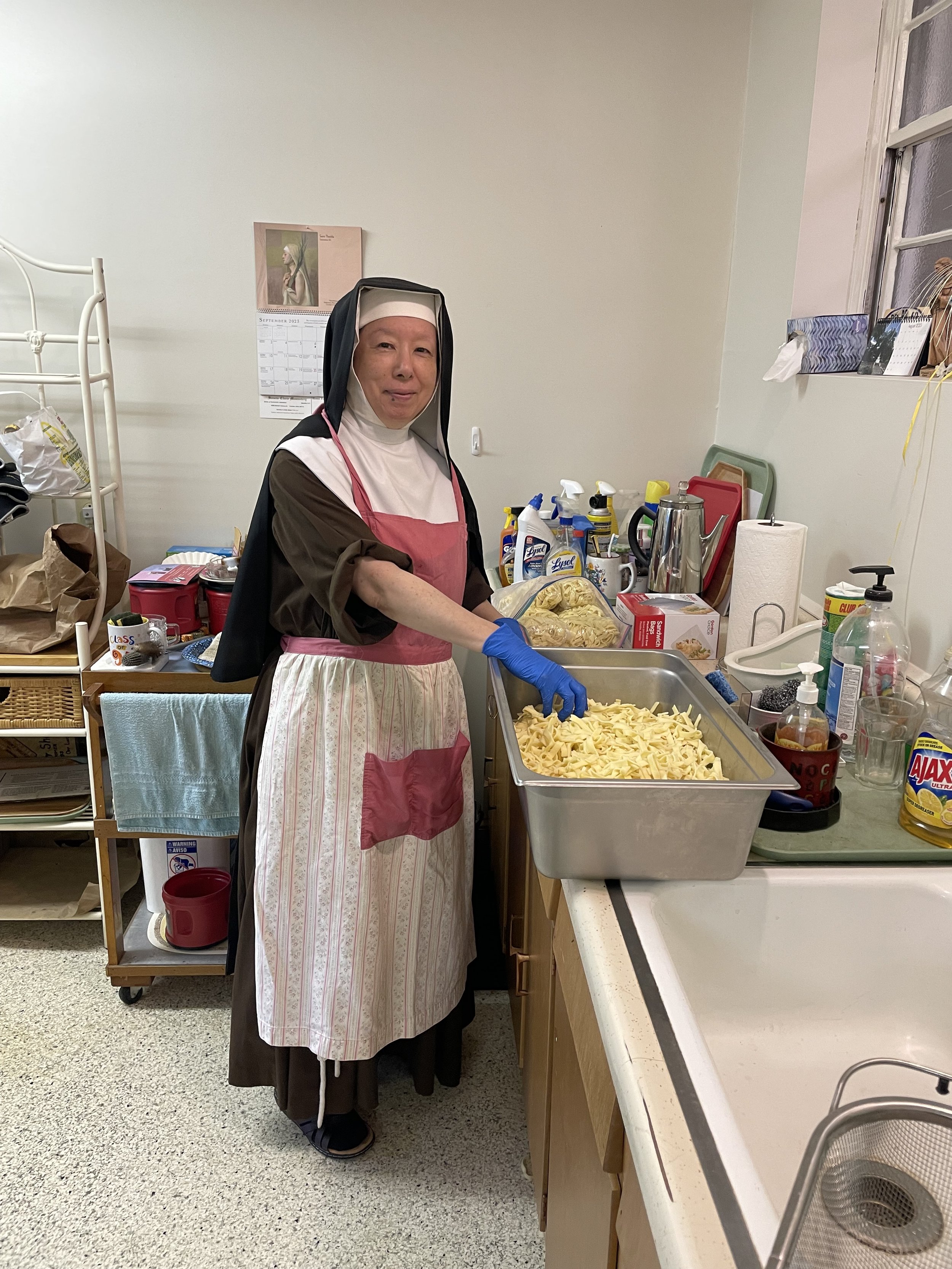 Sr. Marie Dominique helping bag more noodles for the very fast selling chicken noodle soup. 