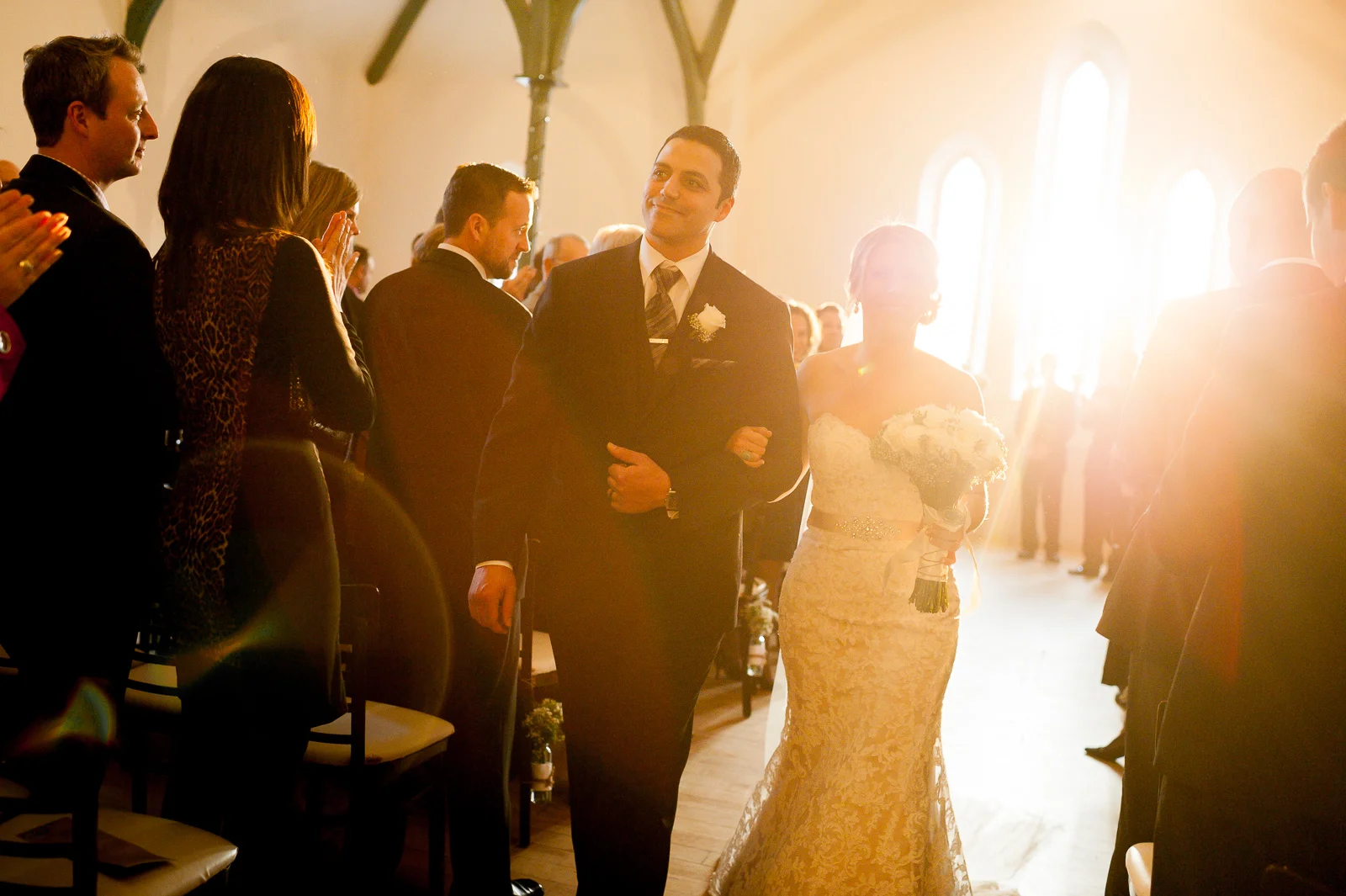 Bride and groom walk down the isle after their wedding ceremony at the Enoch Turner Schoolhouse in Toronto.
