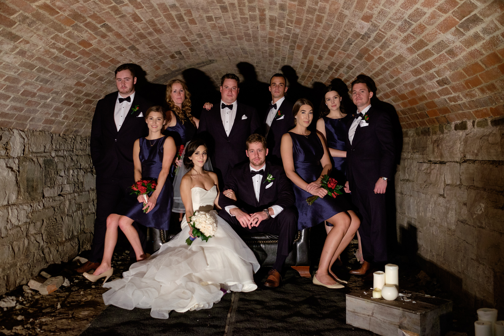 Spencer and Jonas pose with their wedding party for a cool portrait in the old bootlegger tunnels under the Stirling Room.