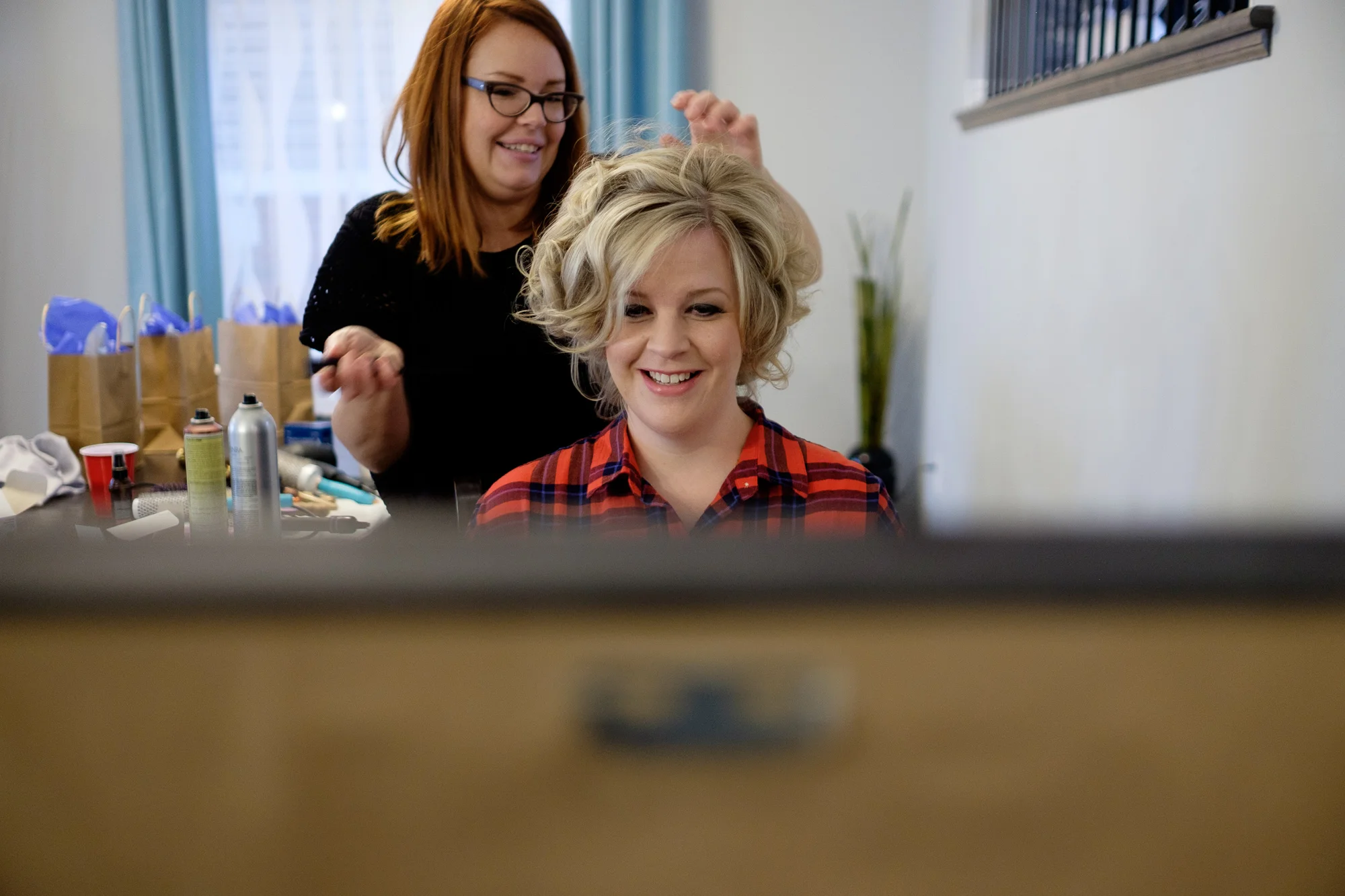 The bride has her hair done before the wedding.