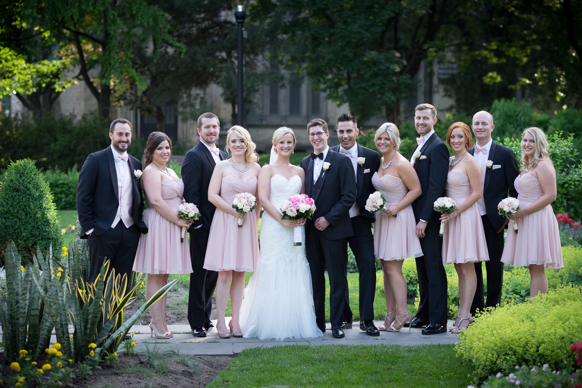 Danielle and Eric pose with for a portrait with their wedding party at a park in downtown Toronto.