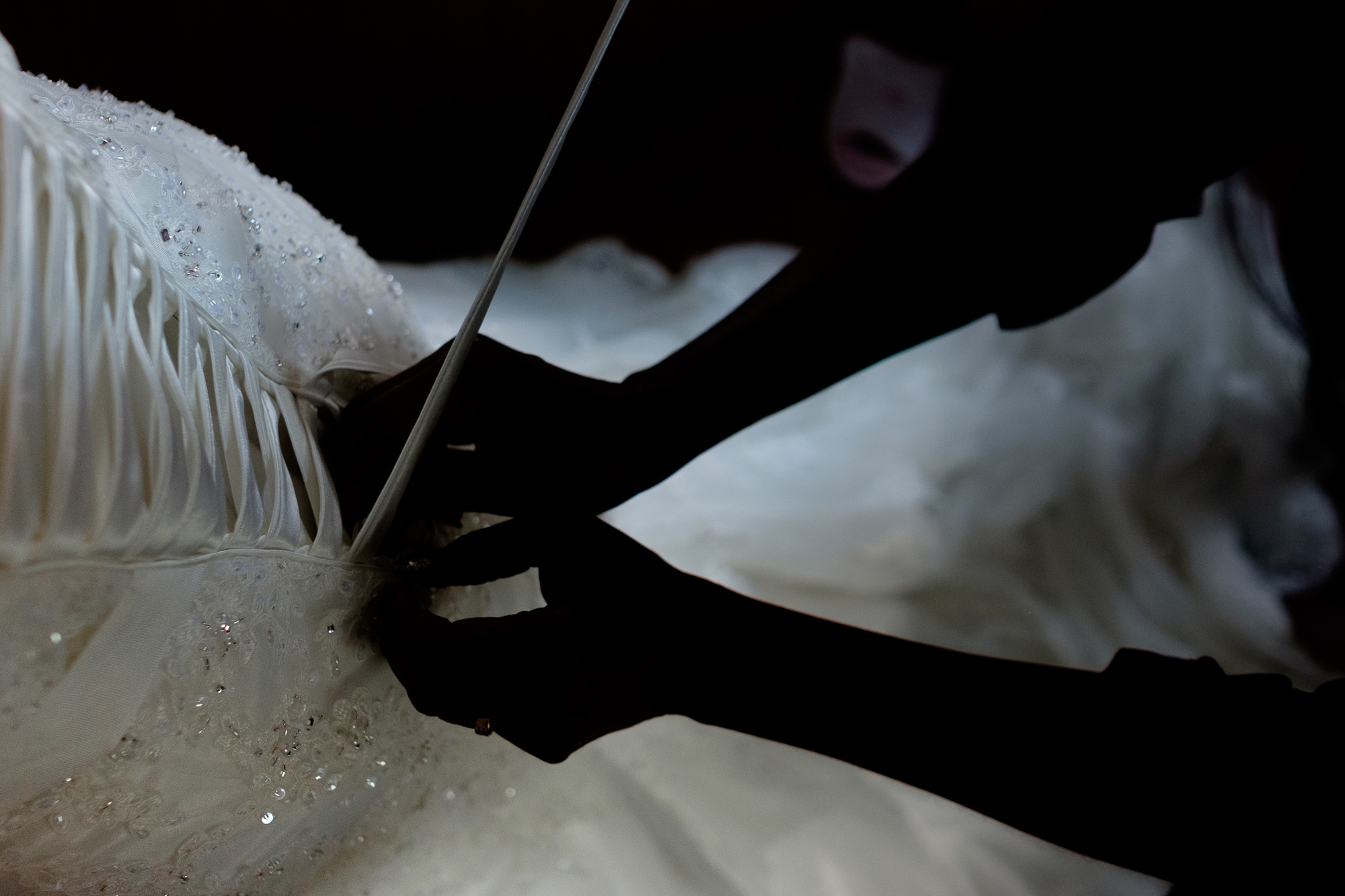 One of Jennifer's bridesmaids finishes lacing up her wedding dress before her Toronto wedding.