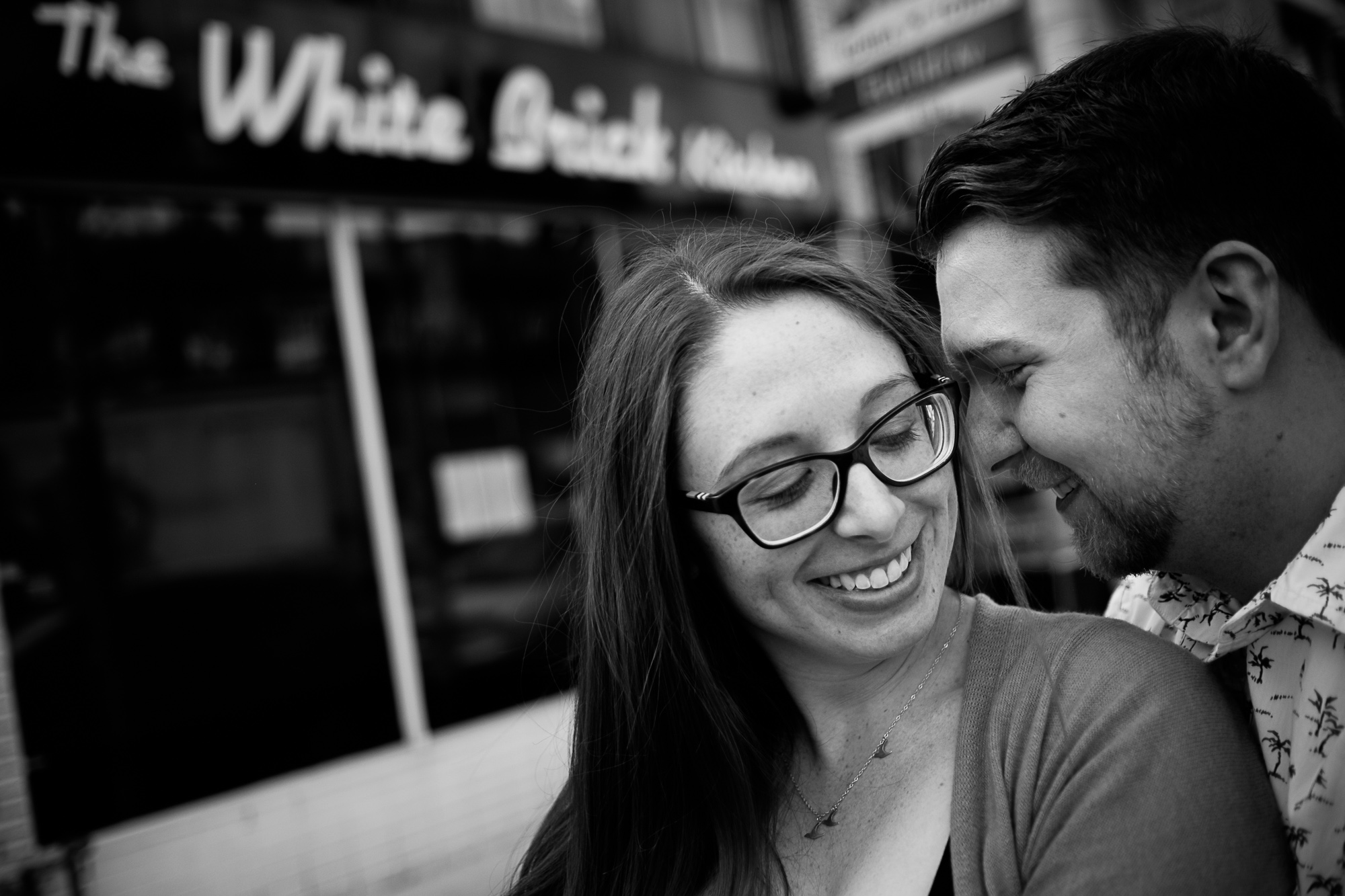 Haley and Stephen pose for an engagement portrait during their engagement session at the restaurant they own in Downtown Toronto.