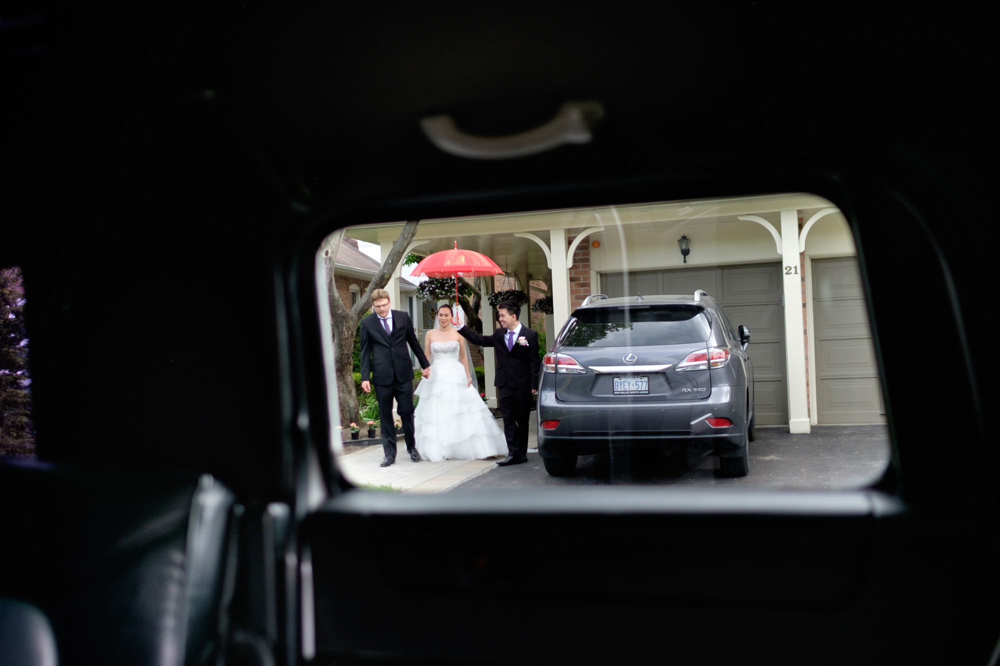  Jing is escorted to the limousine as she is covered by a red umbrella. 