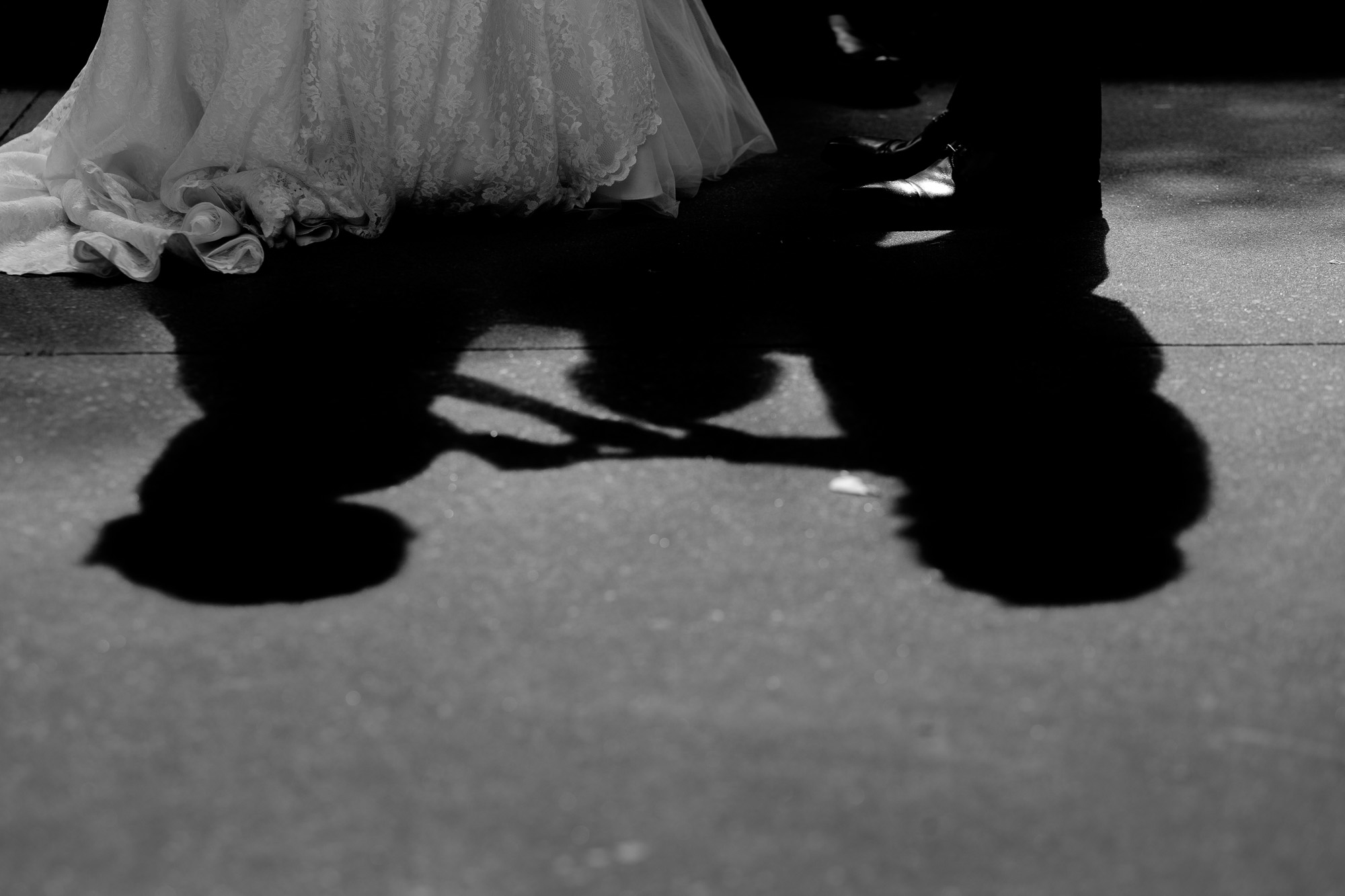  The shadow of the couple as they exchange rings during their outdoor wedding ceremony at the Columbus Centre in Toronto. 