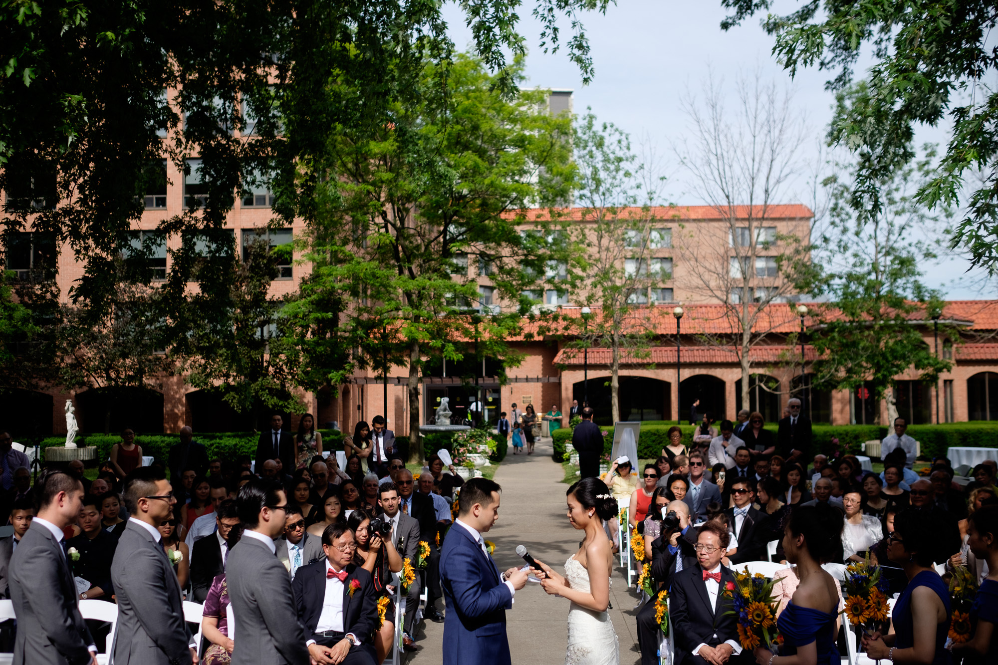  Sherry + jonathan exchange wedding vows during their outdoor wedding ceremony at the Columbus Centre in Toronto.&nbsp; 