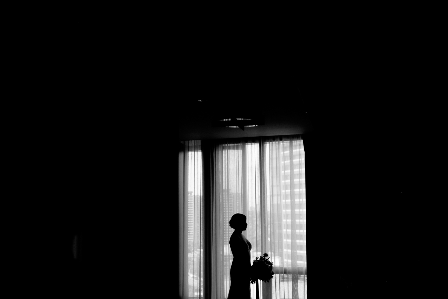 A silhouette wedding portrait of the bride in her suite at the Four Seasons hotel in Toronto.