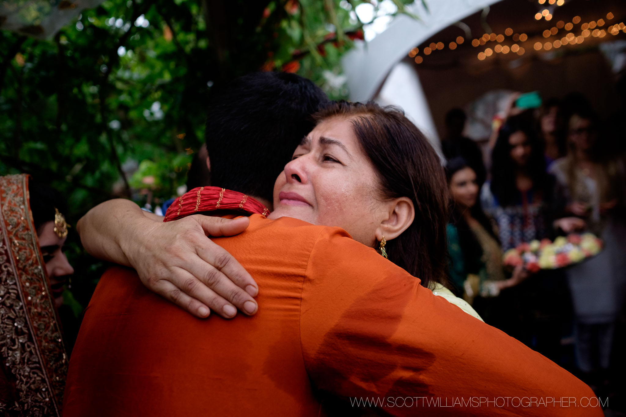  The mother of the bride hugs her future son in law before their backyard wedding ceremony in Burlington, Ontario. 