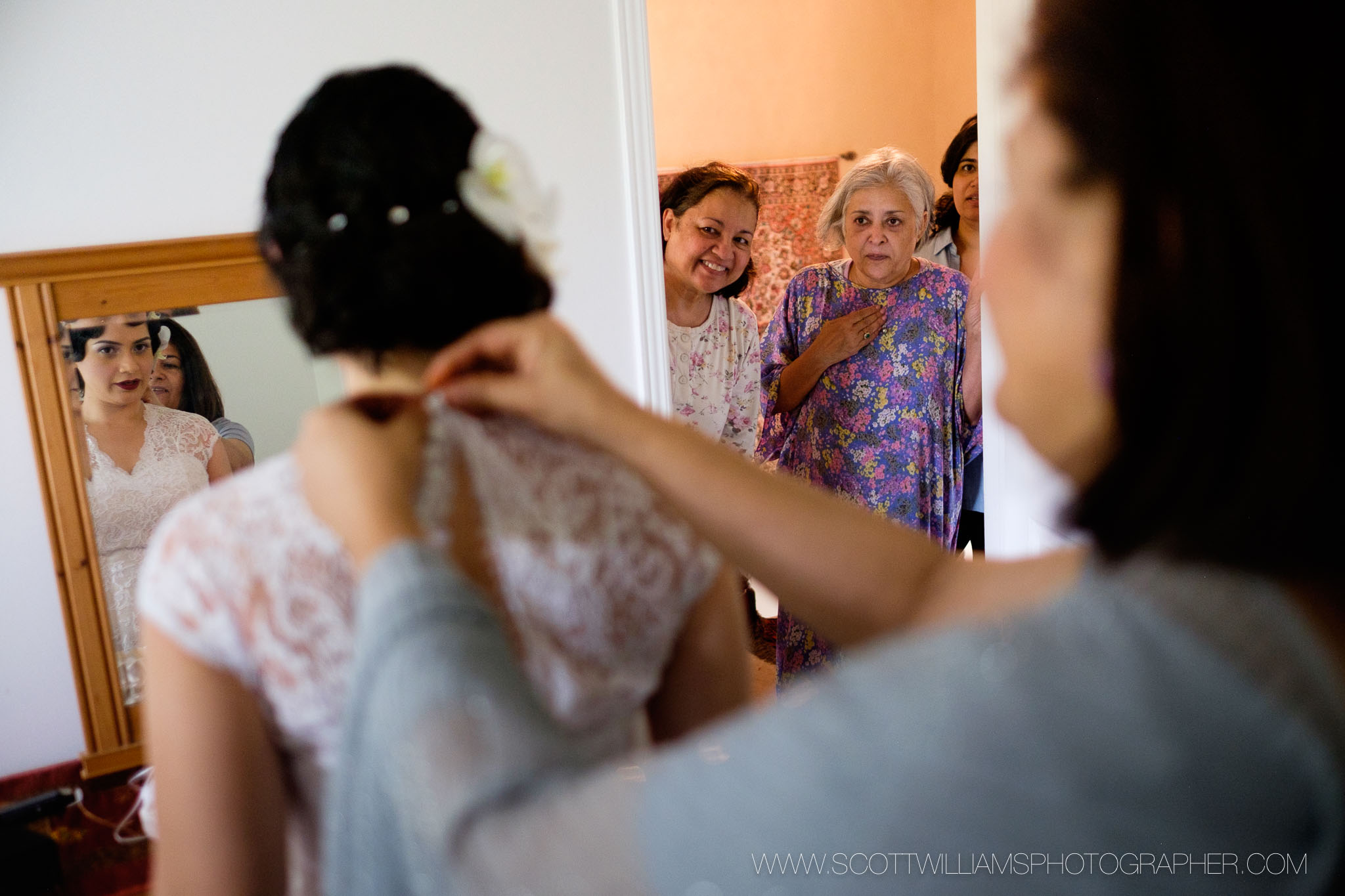  The brides family looks on as she puts her wedding dress on before her wedding at the Ancaster Mill in Ancaster, Ontario.&nbsp; 