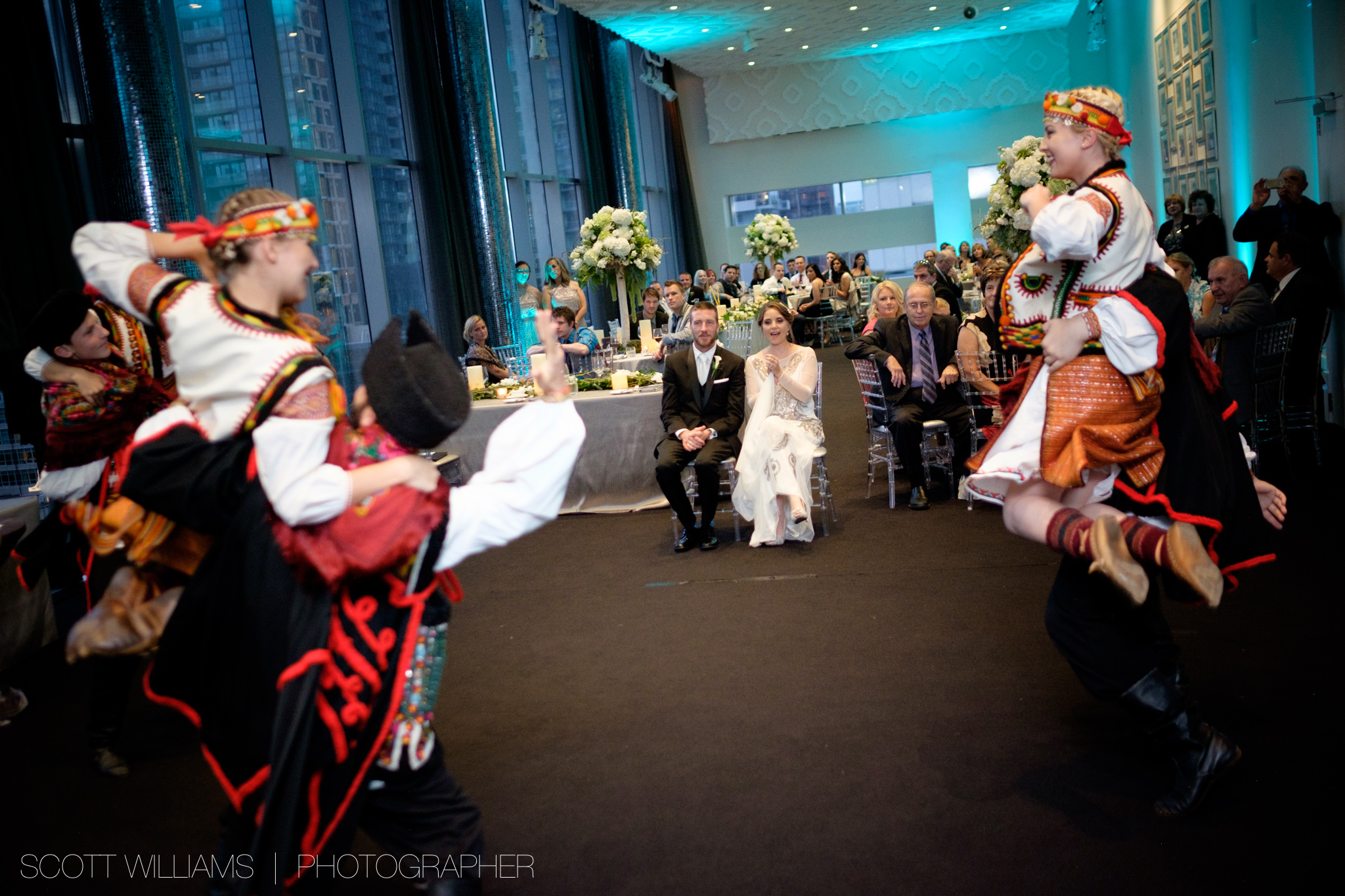  Christina &amp; Tim look on as traditional Ukrainian dancers perform at their wedding reception at Malaparte in Toronto. 