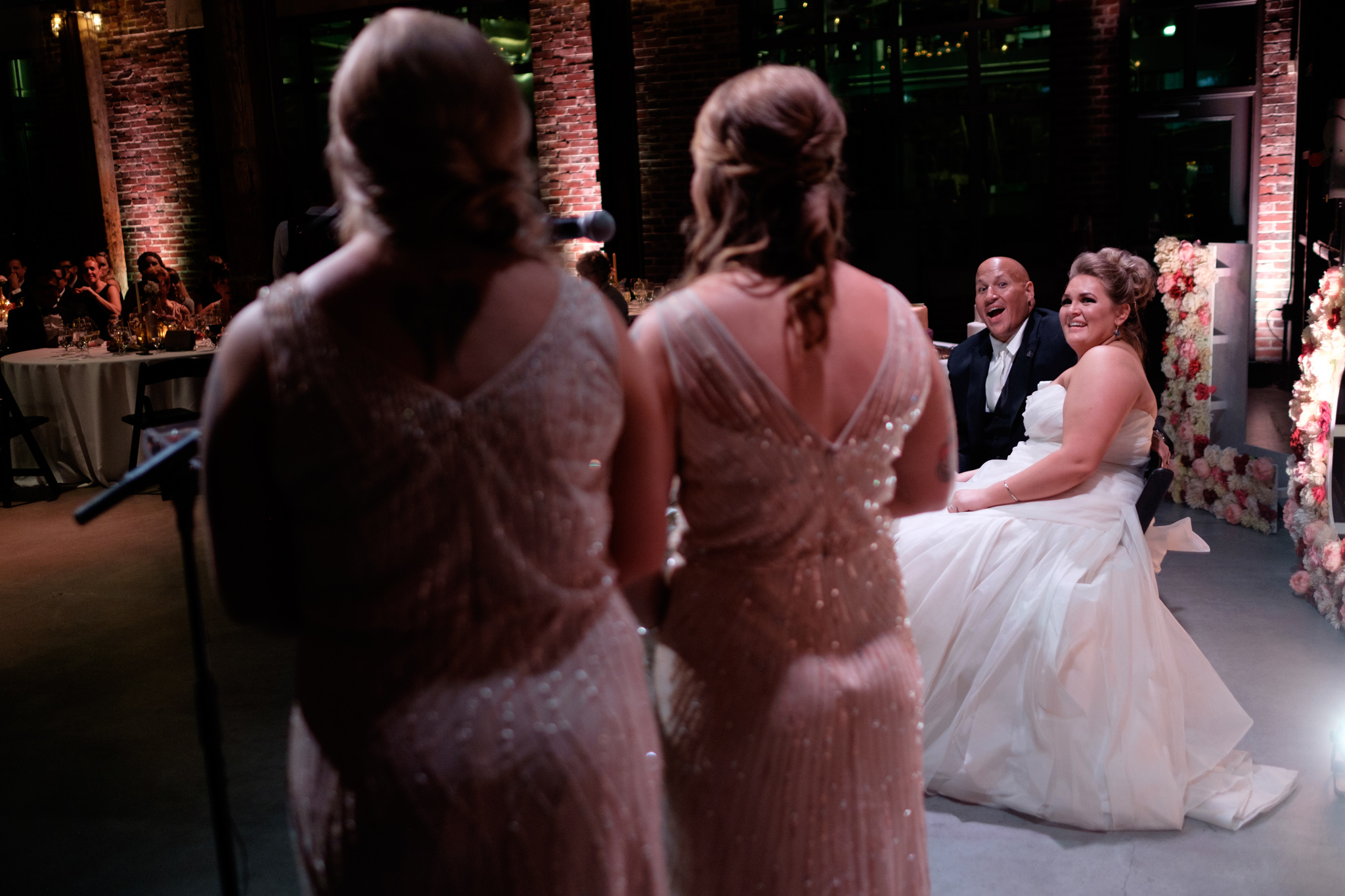  Savannah and Bernie share a laugh as Savannah's sisters give their speech during the reception at their SteamWhistle Brewery wedding in Toronto.&nbsp; 
