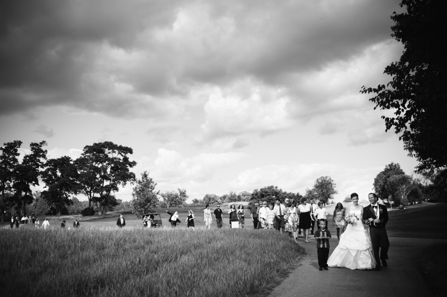 I love this image from Deborah & Joe's wedding at Wildfire Golf Club on the shores of Stoney Lake in the Kawartha region of Ontario. We had just finished their outdoor wedding ceremony in the ruins of an old barn and Deborah + Joe were leading all their guests back to the reception. Usually, after a ceremony it's a bit of controlled chaos as everyone is lining up to get out of the church and then getting into limo's and cars to head to the reception but here it was just a nice moment as everyone walked back and enjoyed the beautful day.