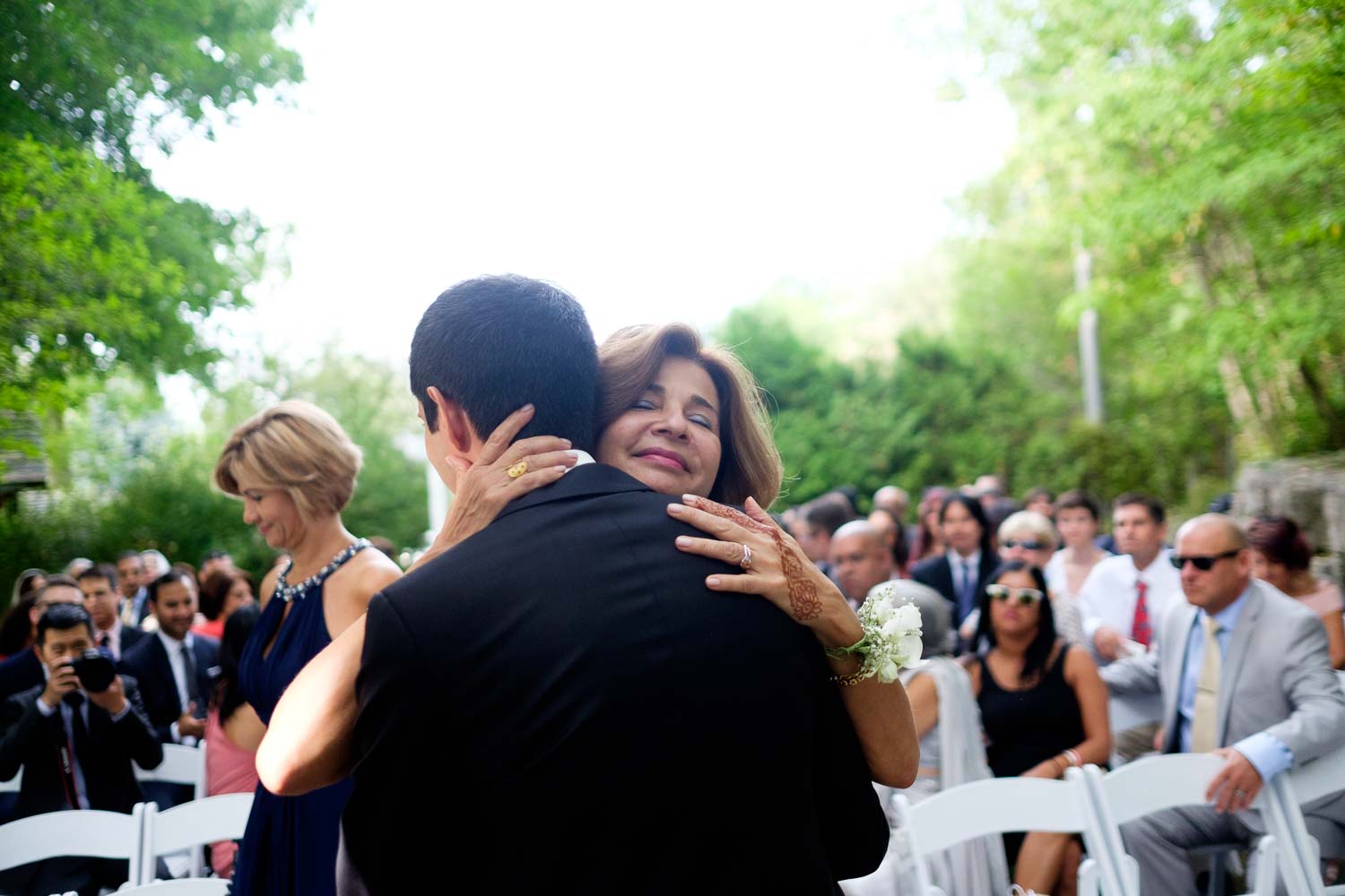 A mother embraces her son during the outdoor wedding ceremony at the Ancaster Mill in Ontario.