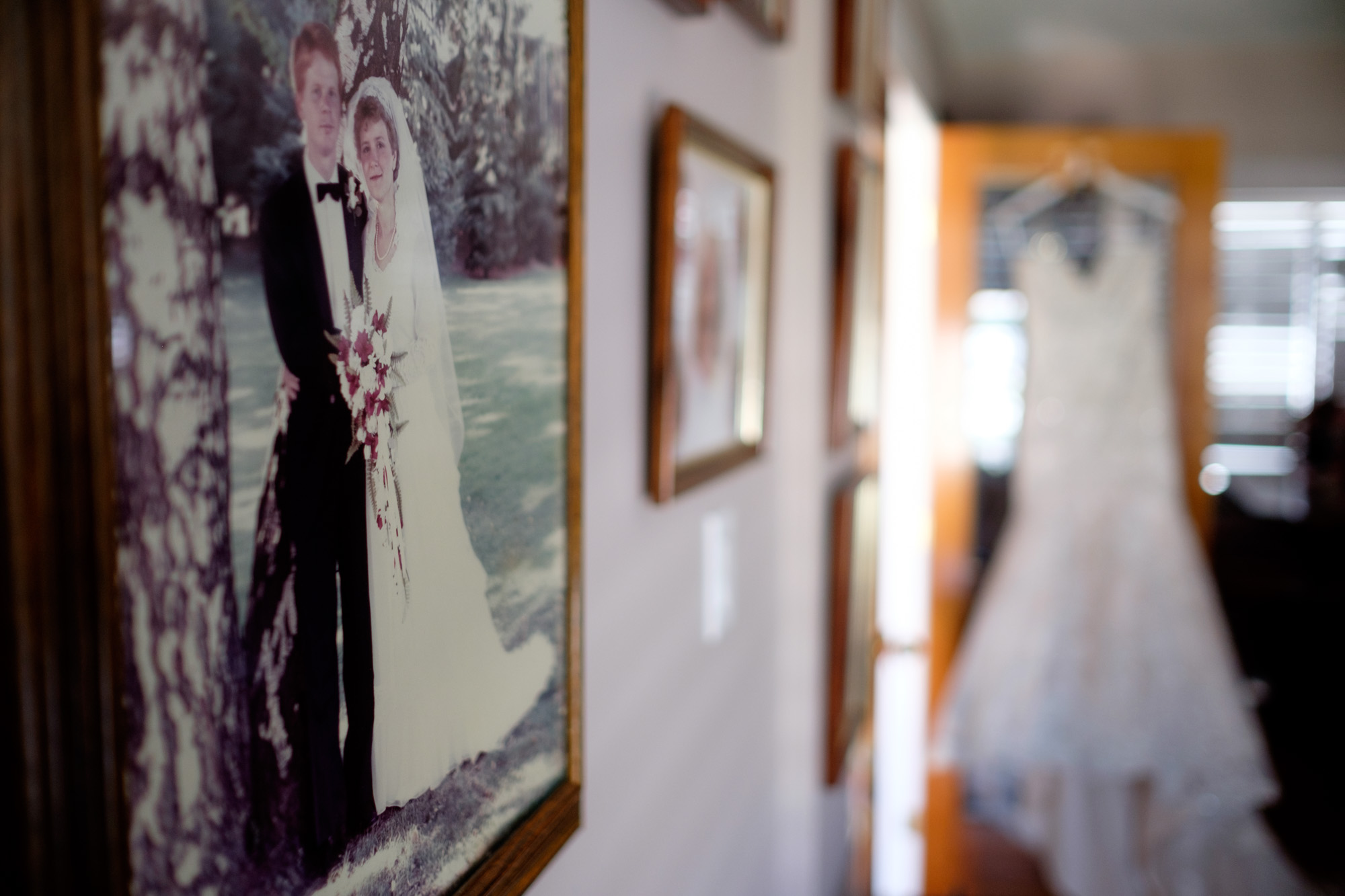The brides wedding dress hangs in her parents home before the wedding ceremony in Cambridge at Whistle Bear. 