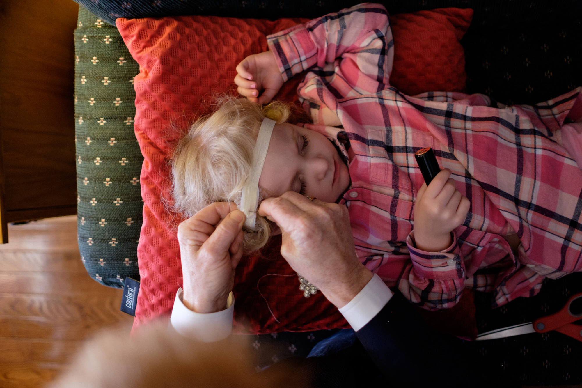 The father of the bride repairs a headpiece for the flower girl before the wedding ceremony at Whistle Bear in Cambridge. 
