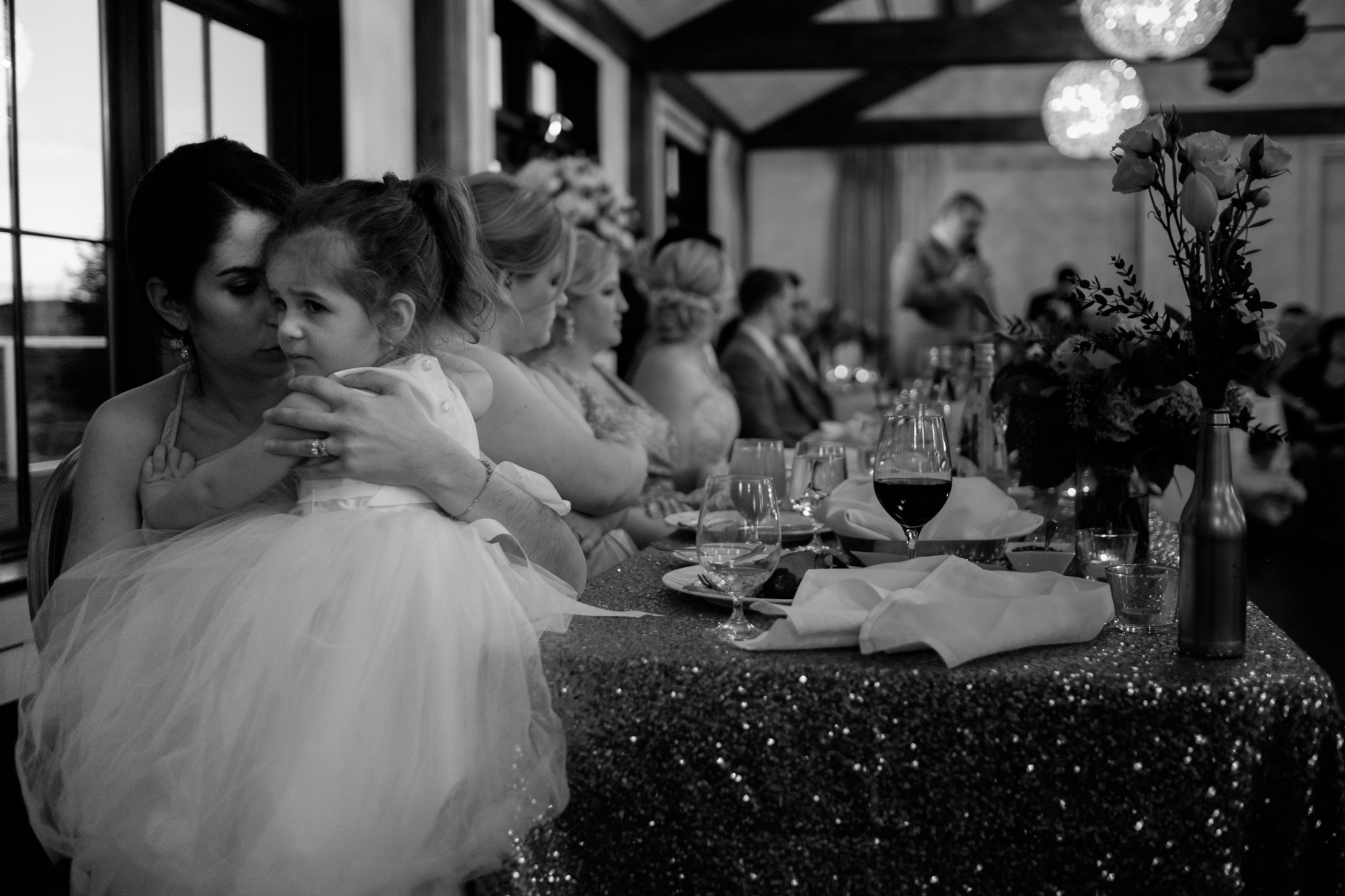The flower girl is comforted by her mom during the reception at Sarah + Rob's wedding at Whistle Bear in Cambridge, Ontario. 