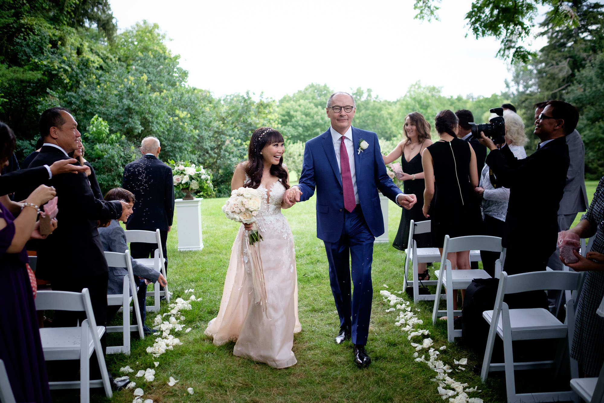  Teresa + Robert dance their way back down the aisle after exchanging wedding vows during their outdoor ceremony at Cambridge's Langdon Hall. &nbsp;Photo by Scott Williams. 