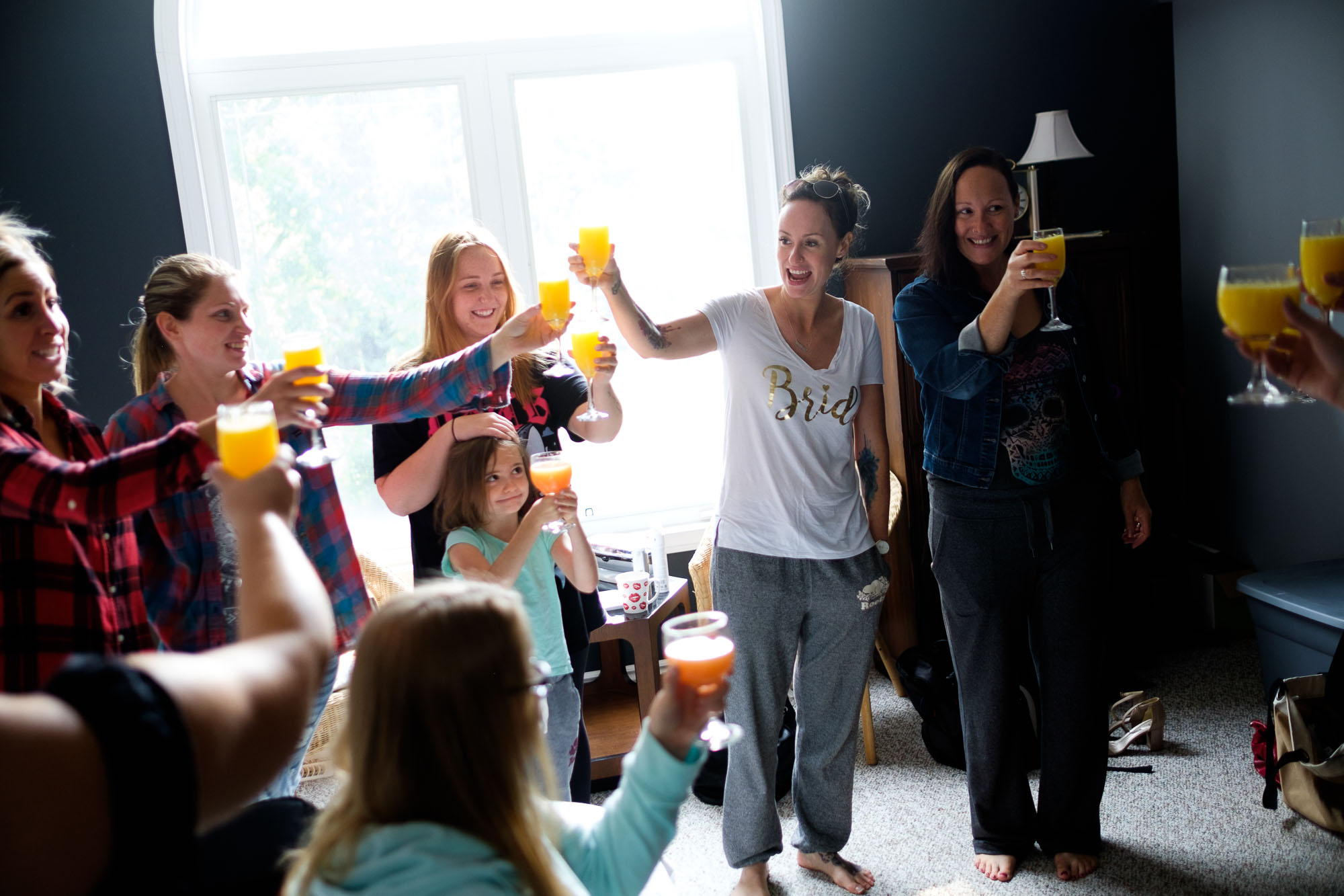  Kristin and her bridesmaids share a toast in the morning before her wedding as they get ready with hair and make up in Barrie, Ontario by Scott Williams. 