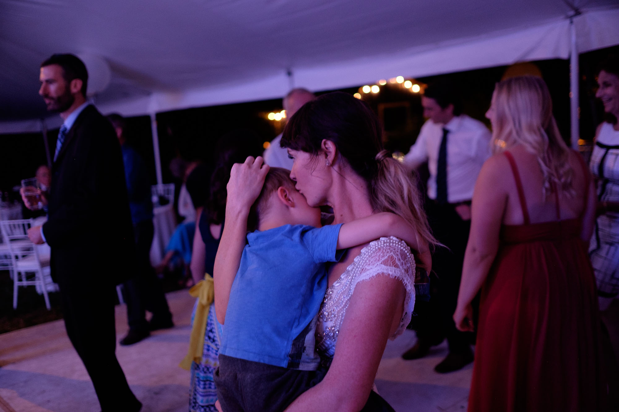 The bride and her son share a moment on the dance floor during the wedding reception in her backyard in Barrie, Ontario. Photography by Scott Williams.