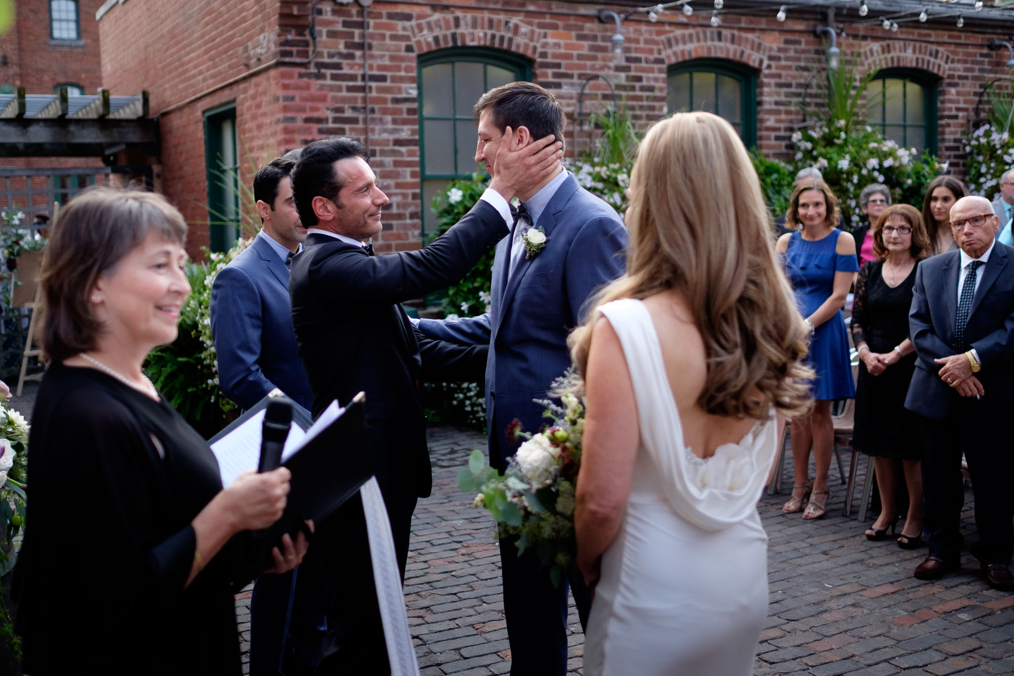  Enrico shakes hands with Cindy's son during their wedding ceremony at Archeo in the historic Distillery District in Toronto. 