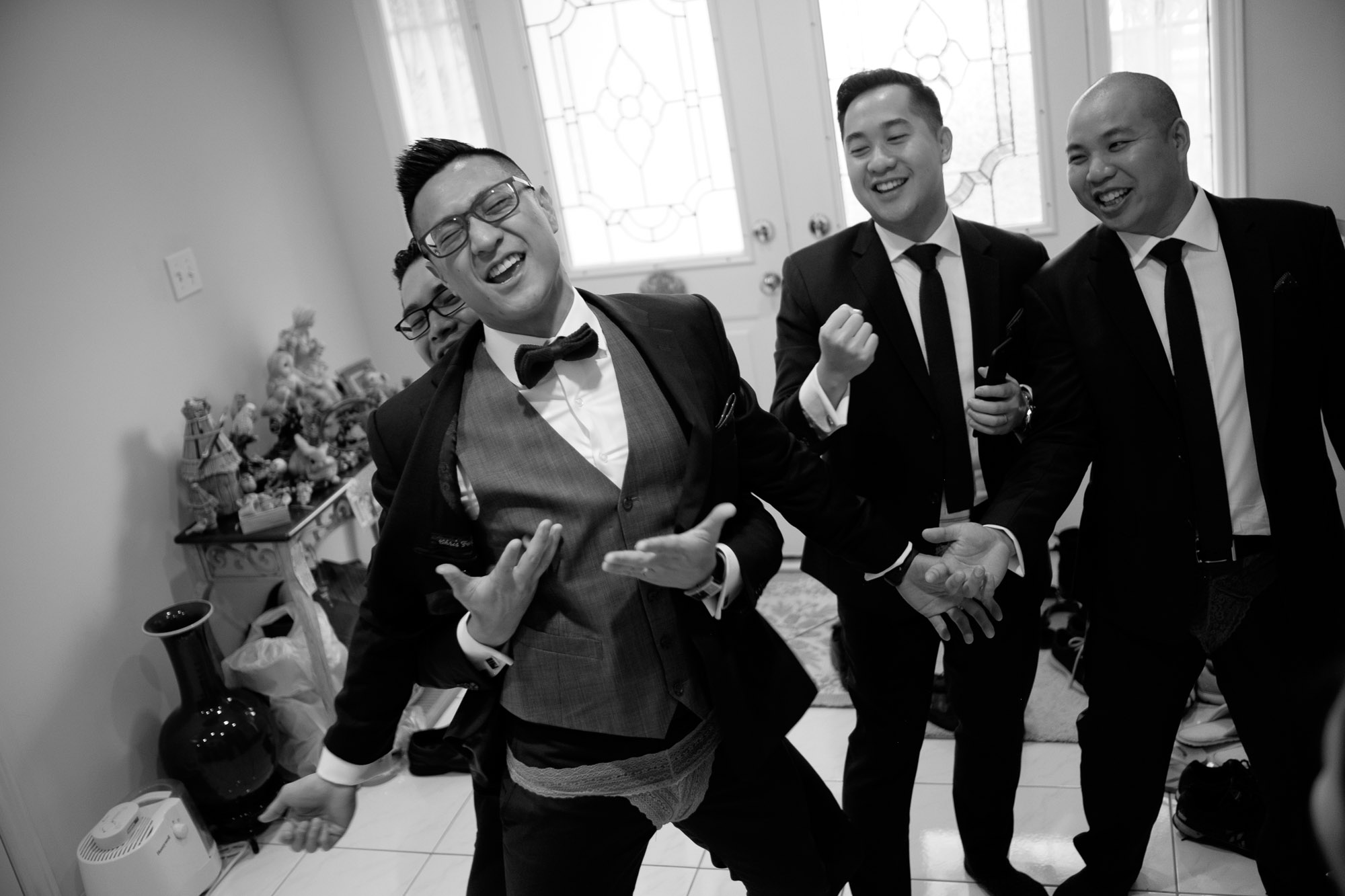 Chris and his groomsmen sing during traditional Chinese door games before their wedding at Madsen's Greenhouse.