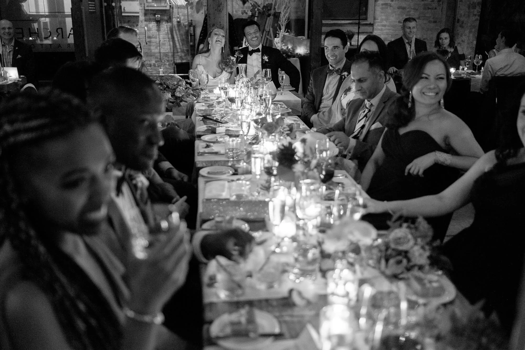 The bride and groom react to a wedding toast during their wedding reception at Archeo in toronto . 