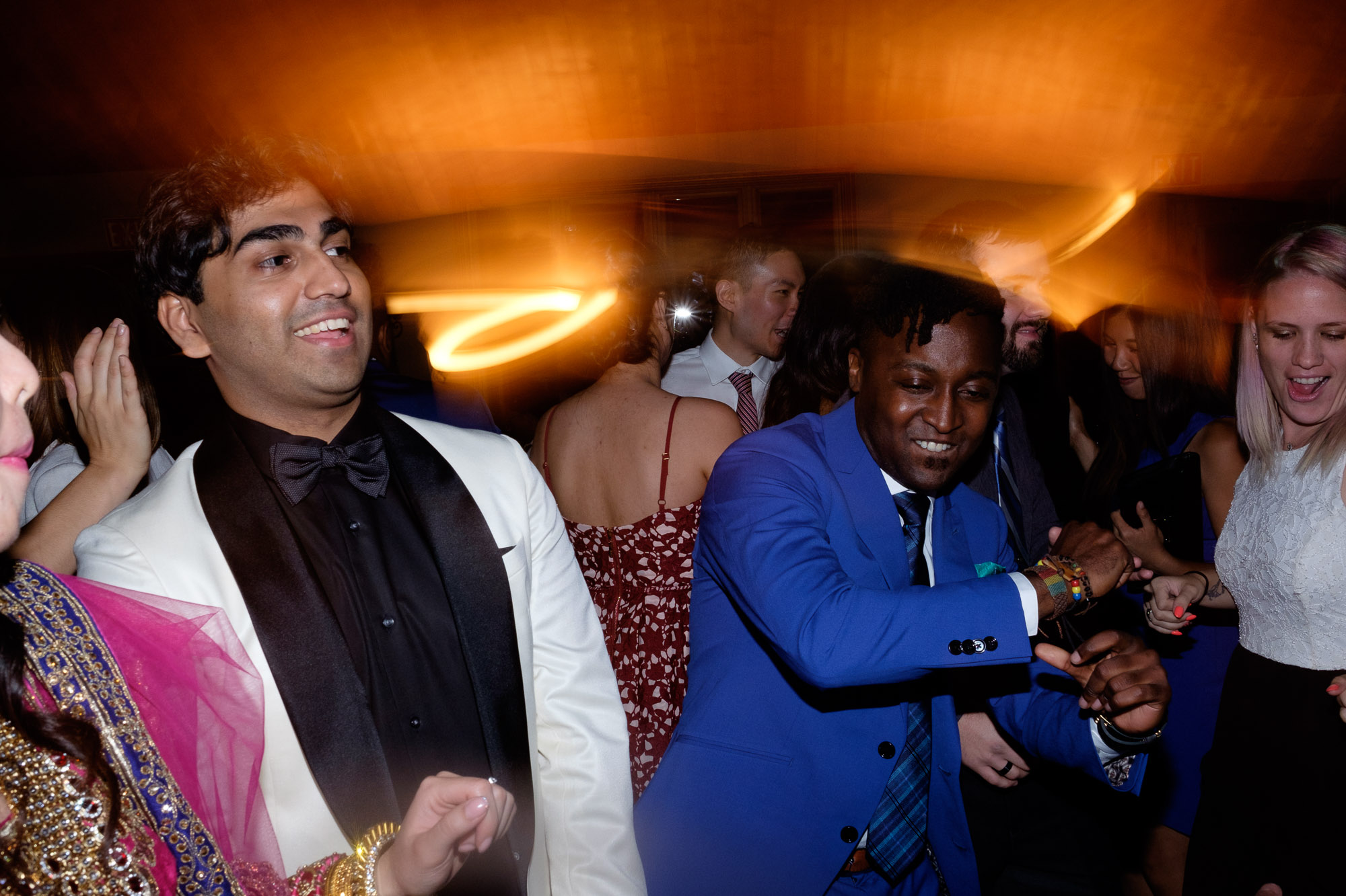 Wedding guests party it up on the dance floor during Chelsea + Danny’s wedding reception at Waterstone Estate.