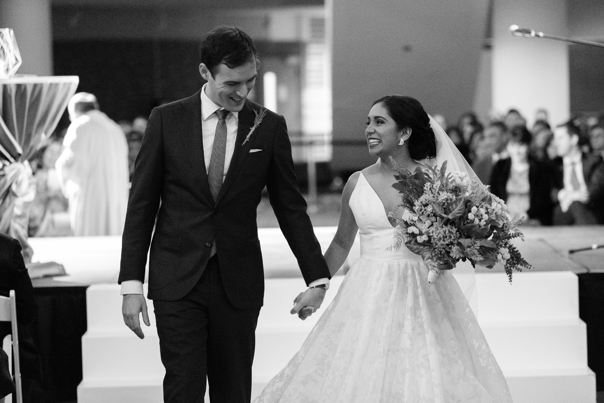  Andrea + Rob share a moment as they walk down the aisle as husband and wife after their new years eve wedding ceremony at the Toronto Reference Library  