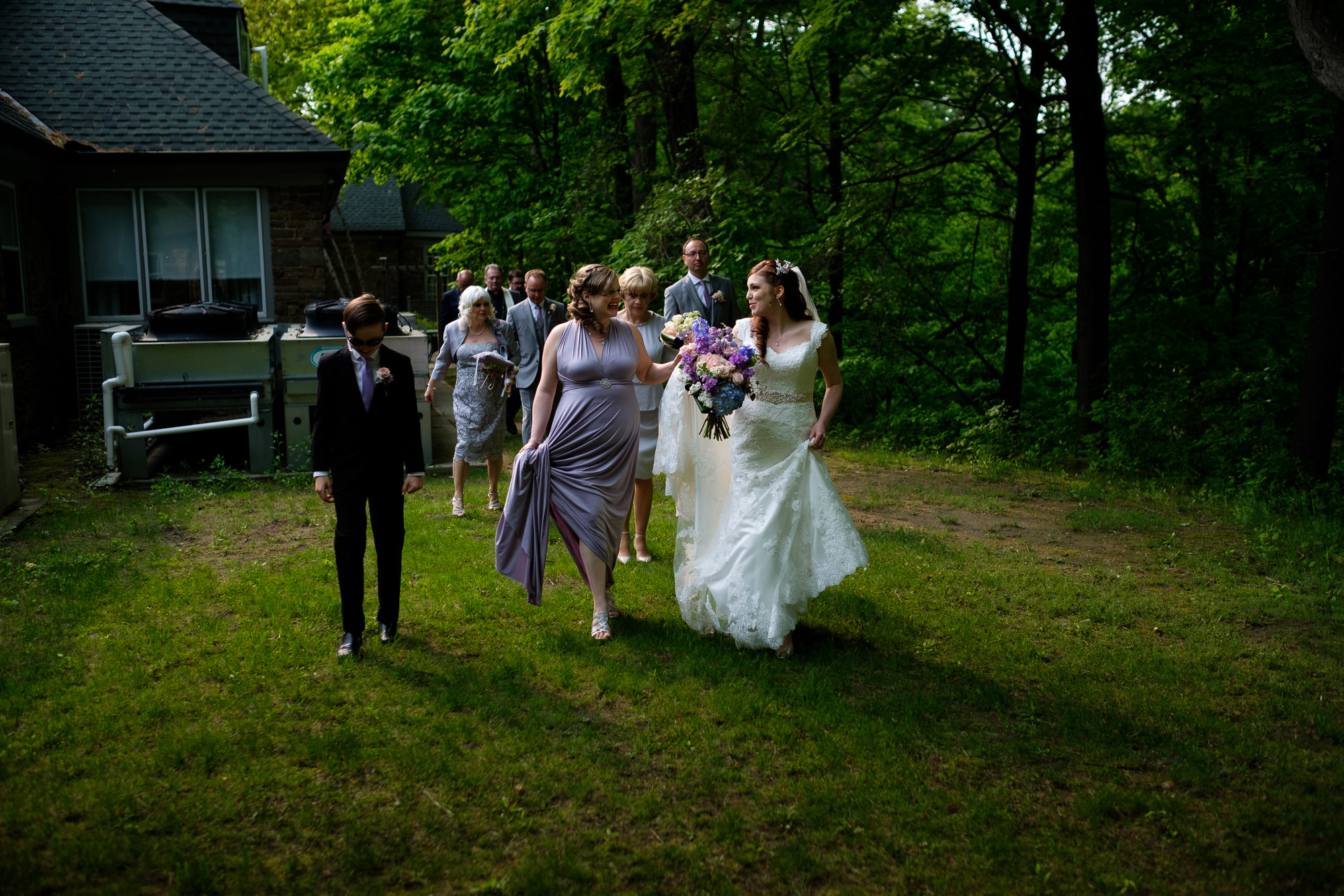 The bride leads her family and friends to the wedding portrait location after the wedding ceremony at the Glenerin Inn just outside of Toronto, ontario.