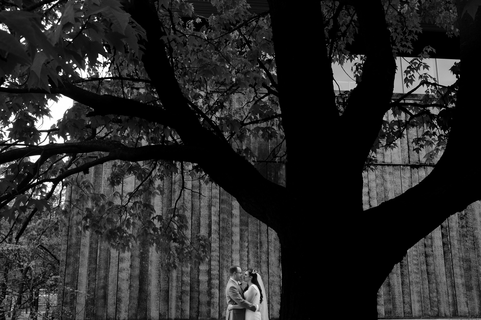 Cheri + Chris pose for a black and white wedding portrait on the grounds of University of Toronto Mississauga after their wedding ceremony at the Glenerin Inn.