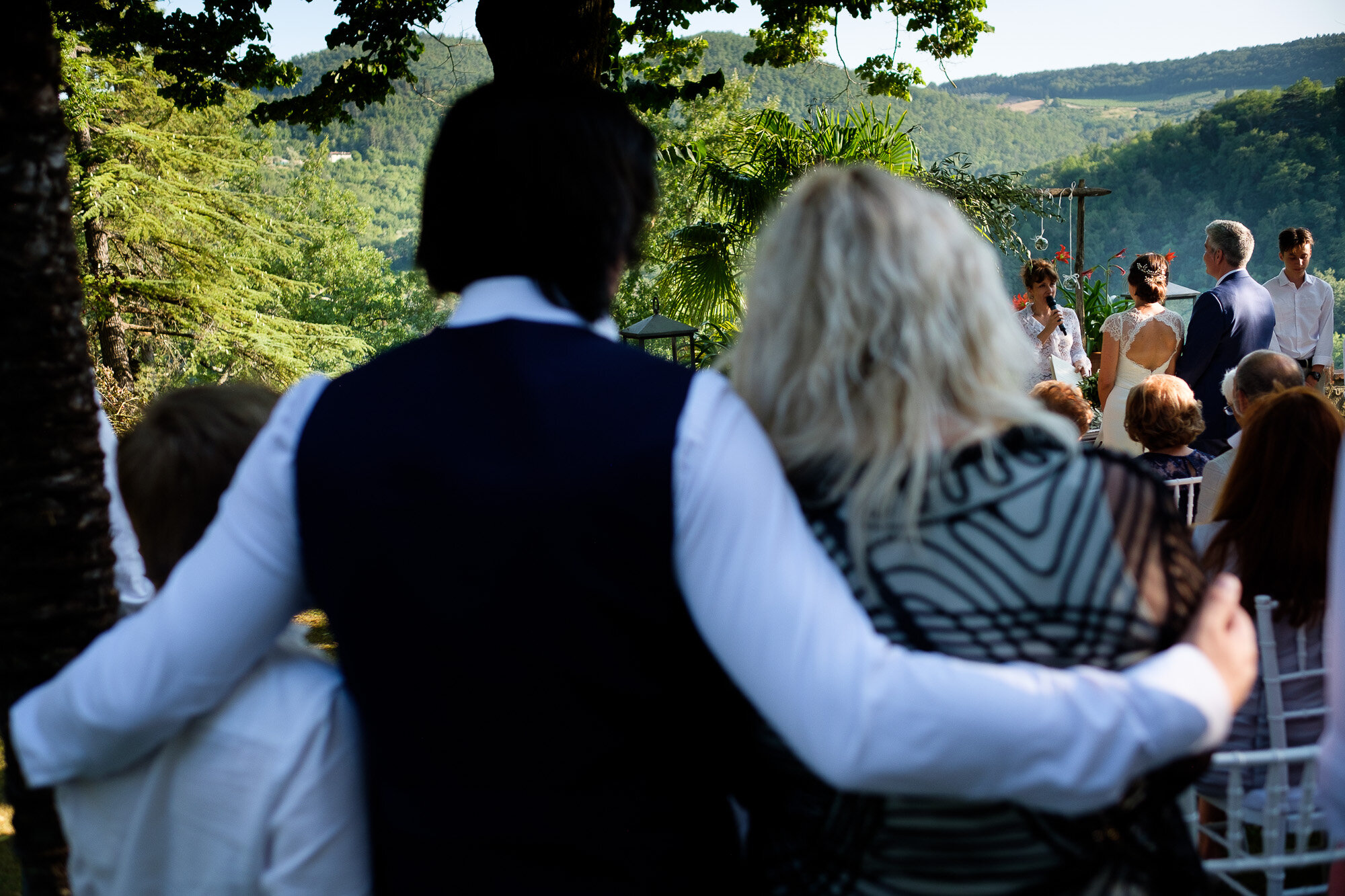 Wedding guests look on during the wedding ceremony of Elena + Steve during their destination wedding in Tuscany, Italy by wedding photographer Scott Williams (www.scottwilliamsphotographer.com)