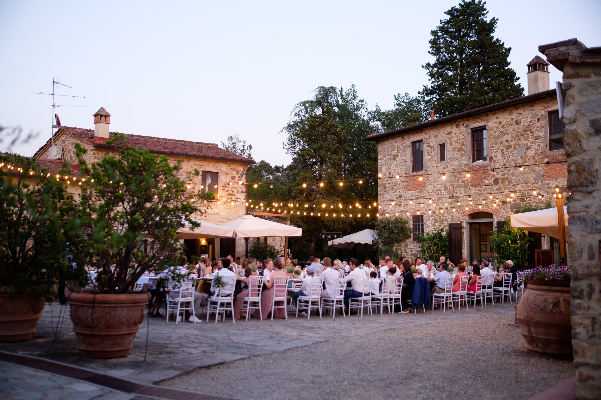  Wedding guests enjoy their dinner during Elena + Steve’s outdoor wedding reception at a villa in Tuscany, Italy by wedding photographer Scott Williams (www.scottwilliamsphotographer.com) 