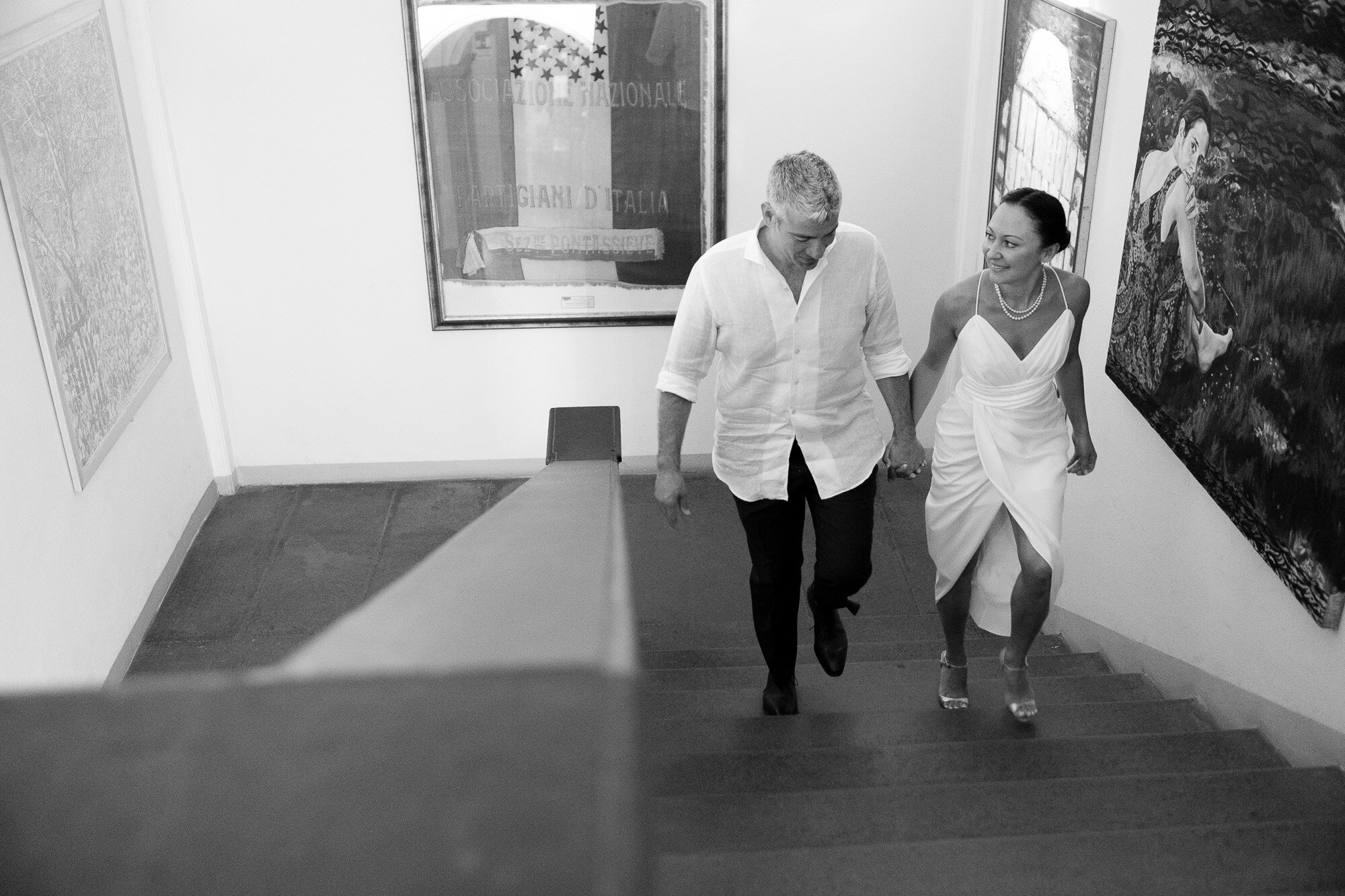  Elena and Steve head up the grand staircase before their civil ceremony at a local towns city hall during their Tuscany destination wedding by wedding photographer Scott Williams (www.scottwilliamsphotographer.com) 