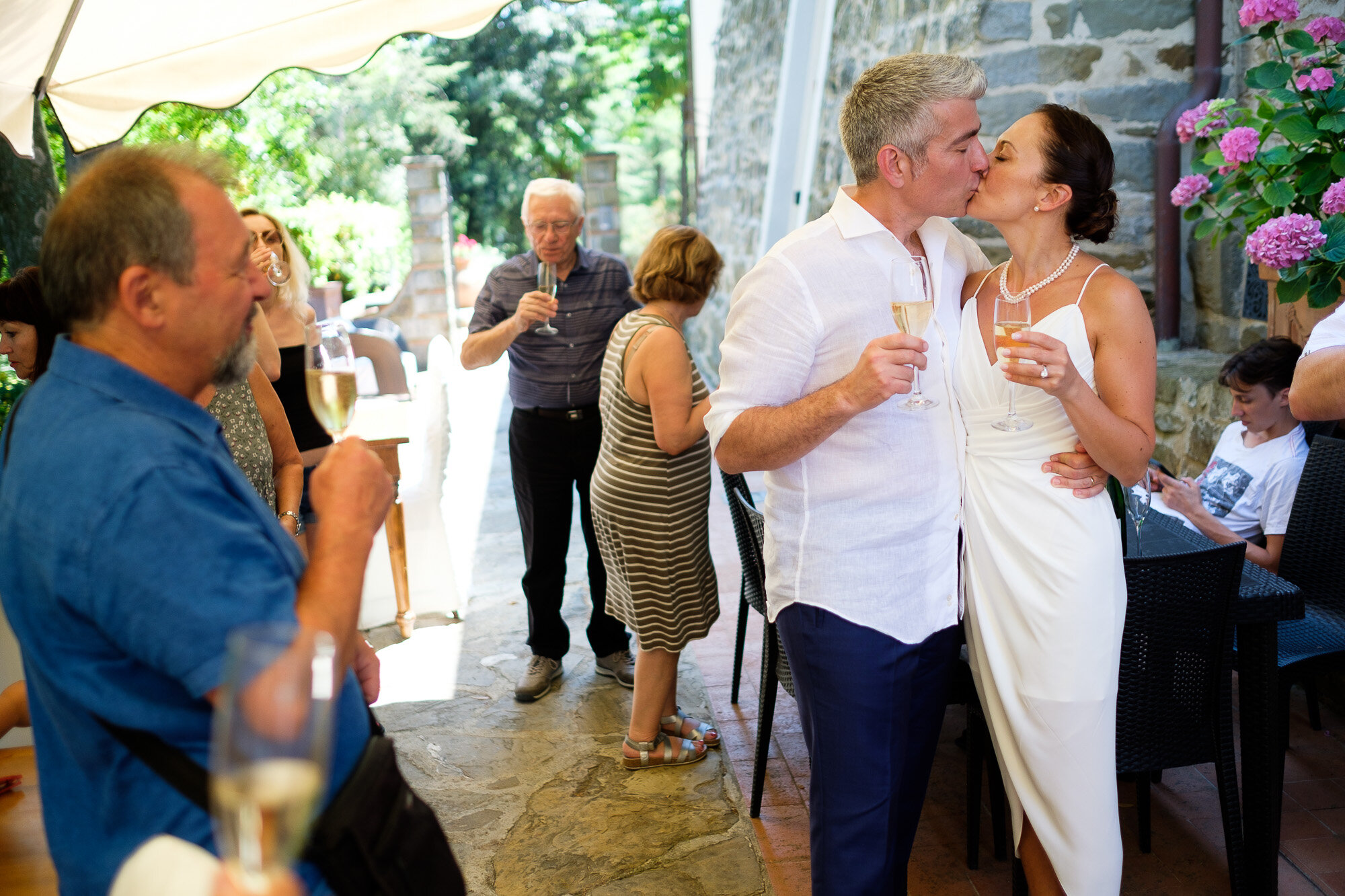  Elena and Steve kiss after their champagne toast at the villa La Sorgente di Francesca during their Tuscany destination wedding by wedding photographer Scott Williams (www.scottwilliamsphotographer.com) 