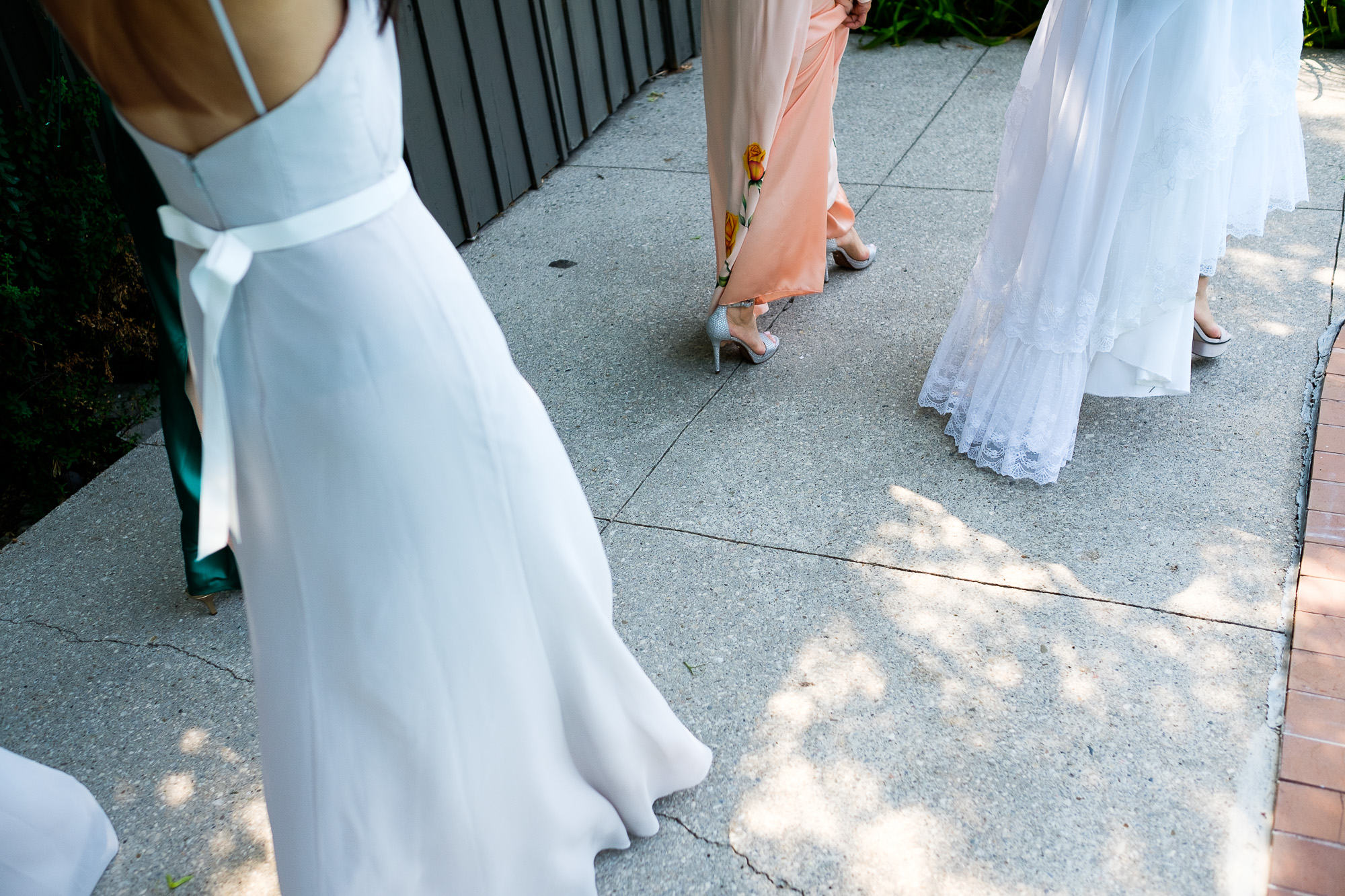 A wedding detail photograph of the bride and bridesmaid dresses after the first look in the backyard.